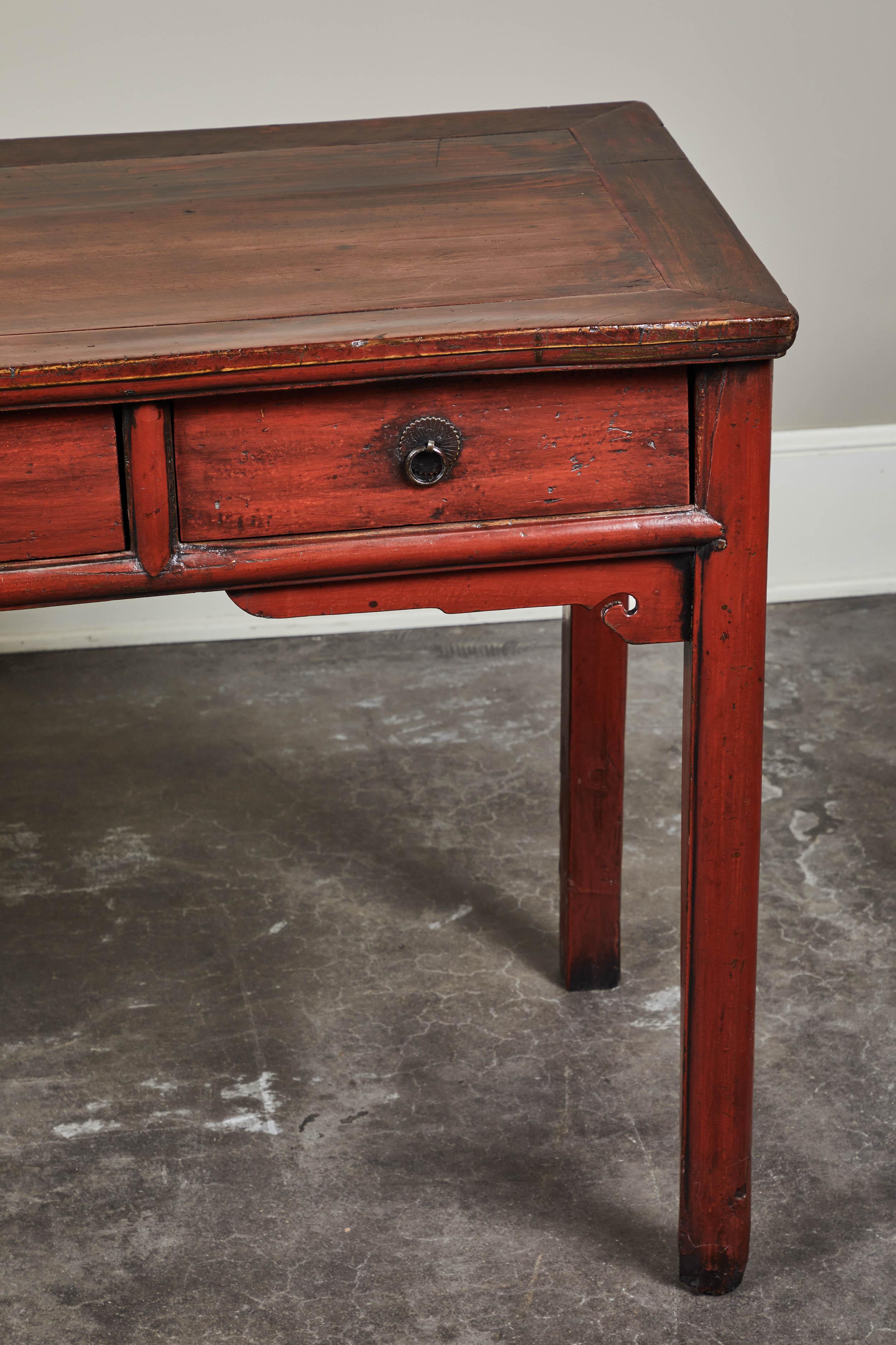 Cinnabar lacquer double faced round leg four door calligraphy table in hard cedar from Jiansu, circa 19th century.