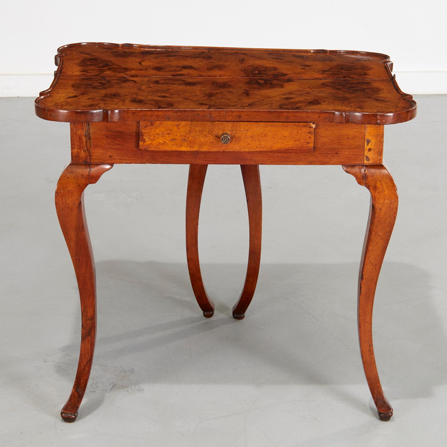 19th c., a rare Eastern European/Circassian games table with particularly fine color and wood graining. The shaped hinge top is over a single frieze drawer, raised on cabriole legs, and includes burled walnut bookmatched veneers on the open table