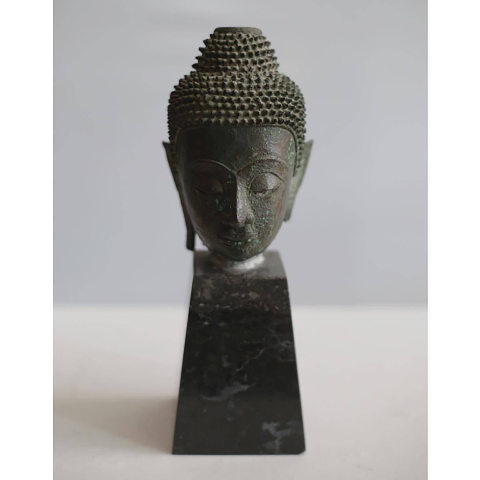 ABOUT

This is an original lost-wax casting bronze head of Buddah Shakyamuni from the 19th century, Thailand. It is mounted on a contemporary marble base and wood base. His meditative expression, arched eyebrows, downcast eyes, smiling lips,