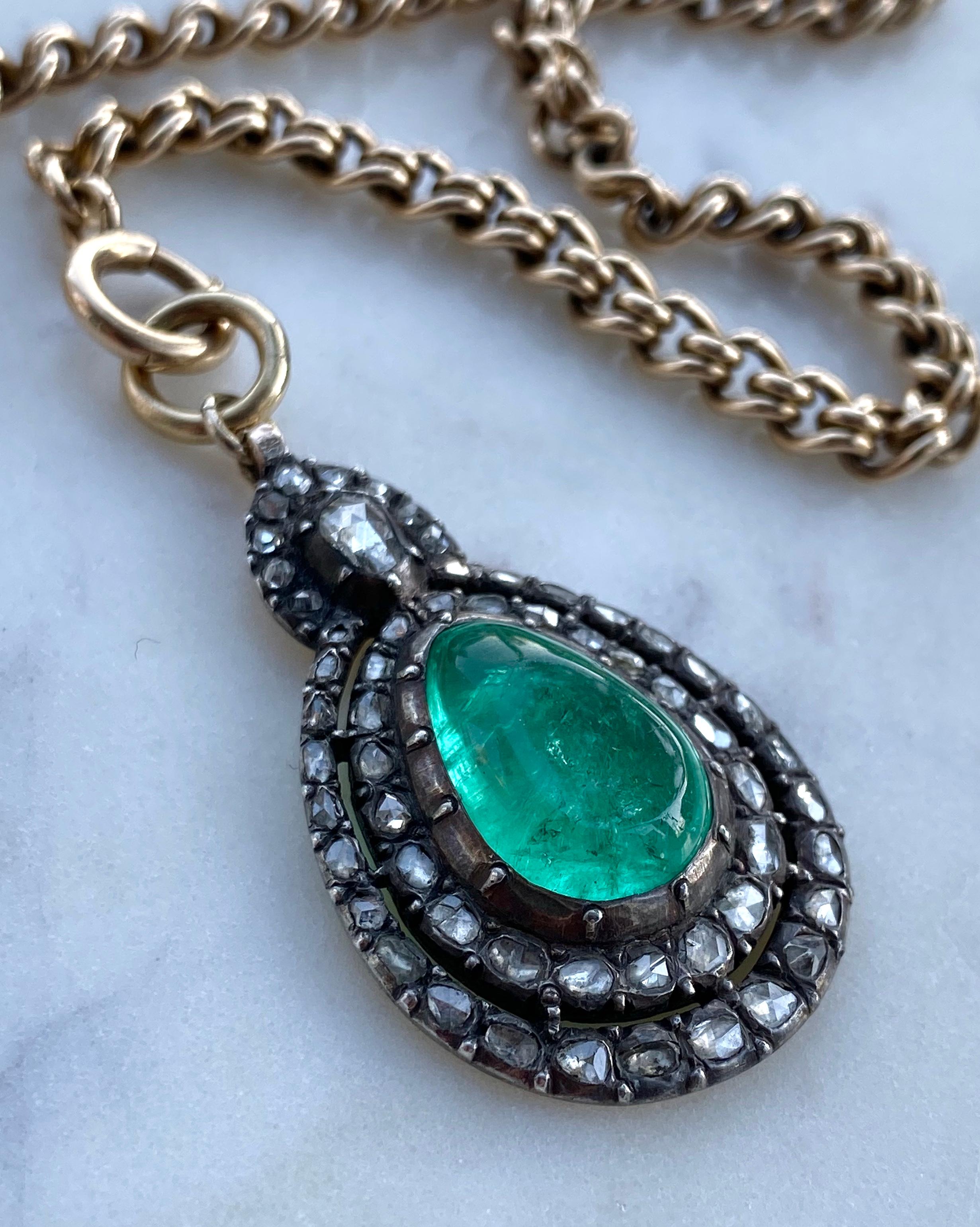 This gemmy Colombian emerald pendant was once likely part of a larger necklace dating to the early to mid 19th C. Weighing approximately 12 carats, this vibrant emerald glows from within a double frame of sparkling rose cut diamonds, hand-fabricated