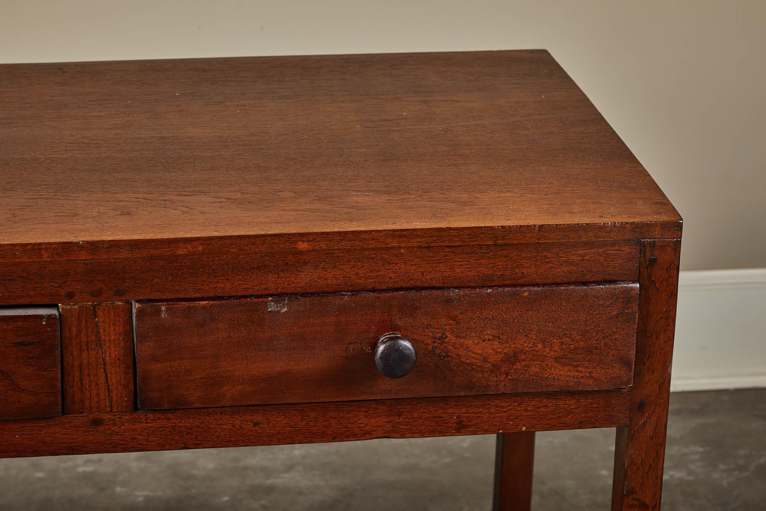 A 19th century colonial teak console table with two drawers and a bottom shelf.