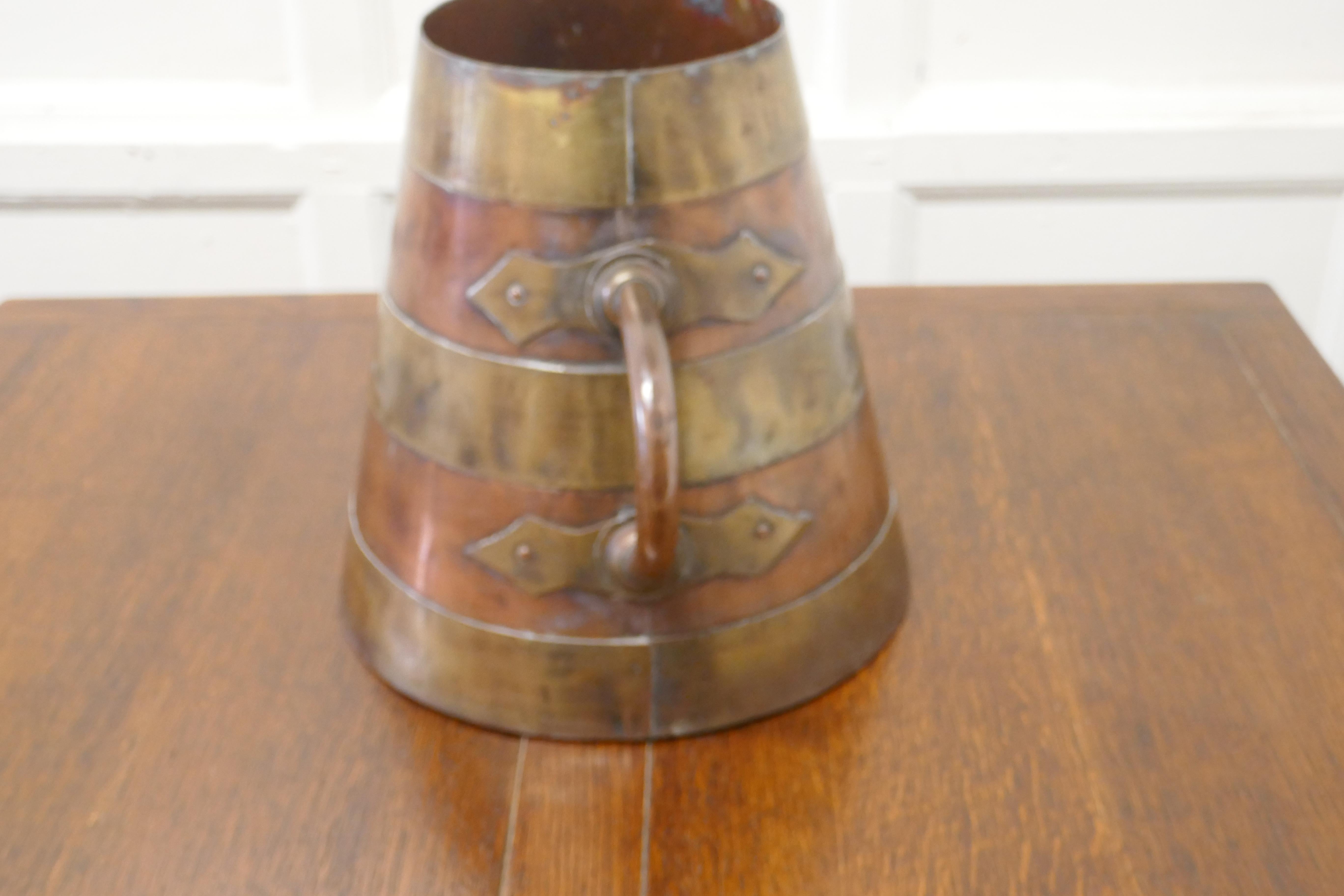 19th C Conical French copper brass banded measure

A super large piece from France the pot has conical shape and strong riveted handles
It is in good condition and is 11” tall, 12” in diameter 
TNV215.