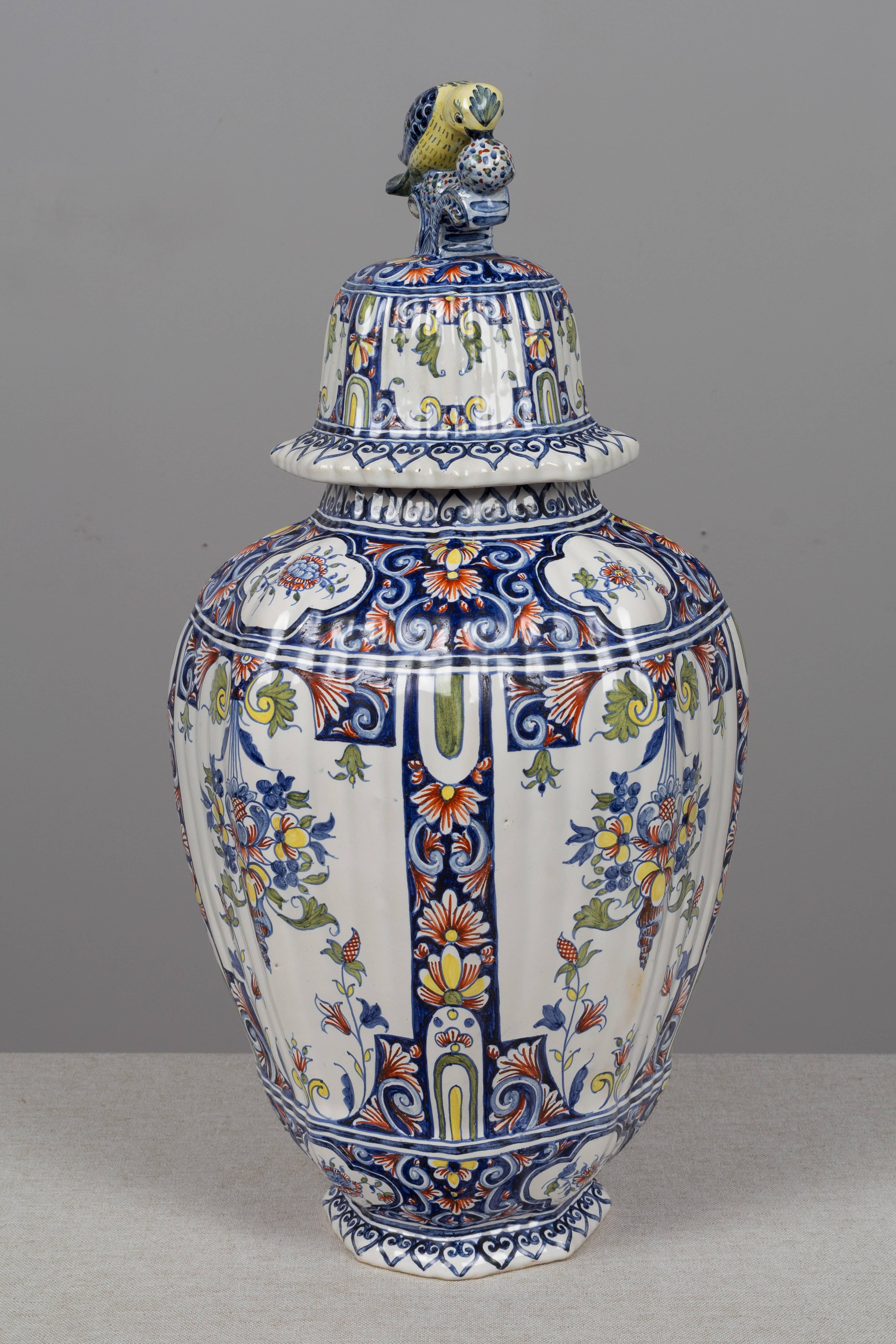 A large 19th century delft faience octagonal ginger jar with colorful hand-painted floral decoration. Domed lid with a bird perched on top. Please refer to photos for more details. We have a large selection of French antiques at Olivier Fleury, Inc.