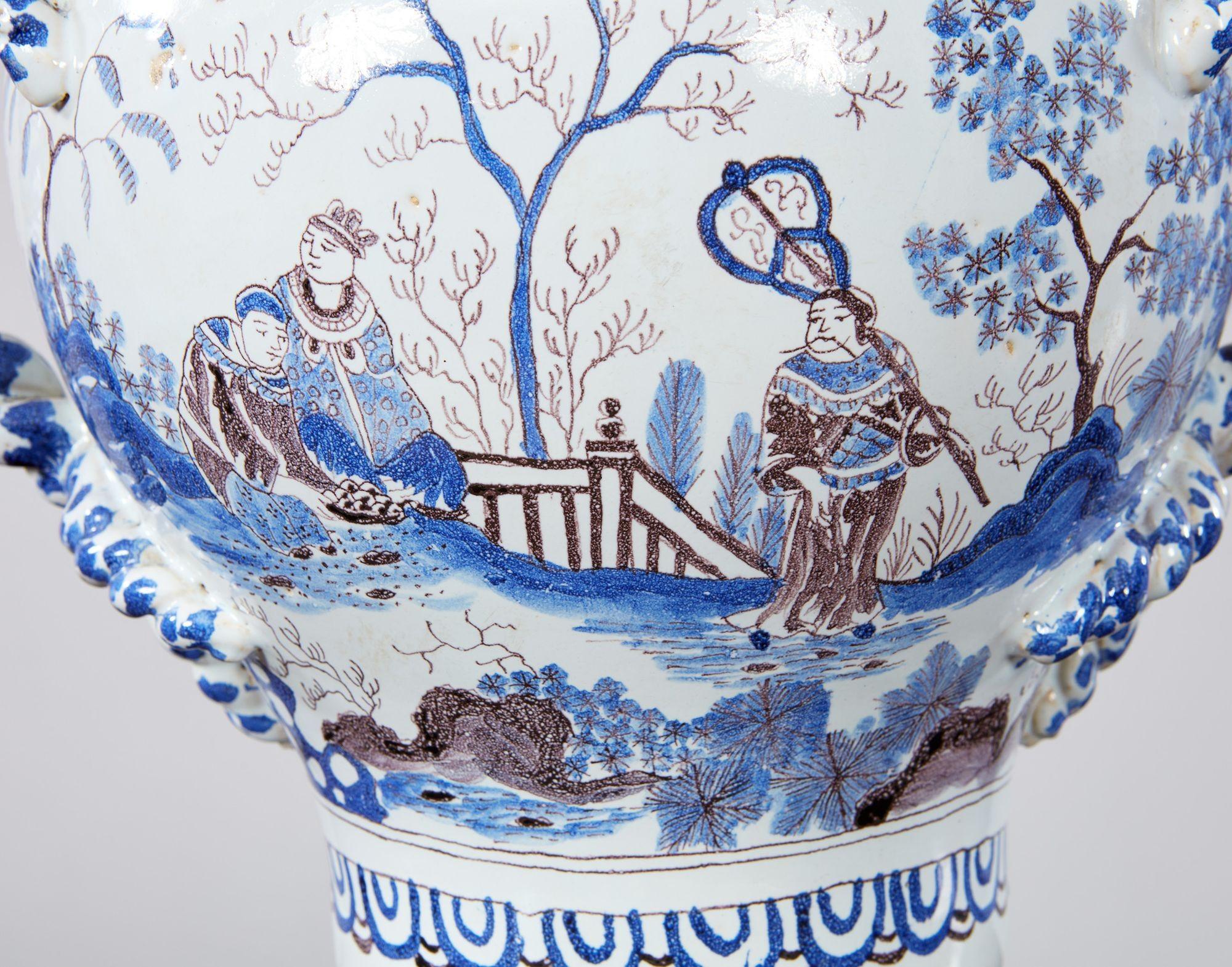 Urne de Delft du XIXe siècle avec couvercle et deux remarquables anses en vigne tressée sur un corps vasif décoré dans différentes nuances de bleu et de charbon de bois de scènes orientales peintes à la main et habilement exécutées, y compris des