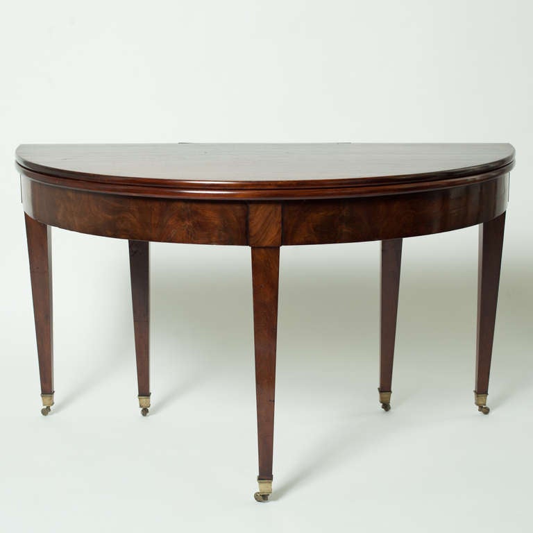 Elegante table de salle à manger Demilune Directoire. Fabriqué en bois de chêne et placage, les pieds se terminent par un sabot en bronze. Lorsque la table est ouverte, ils ont un diamètre de 130 cm.