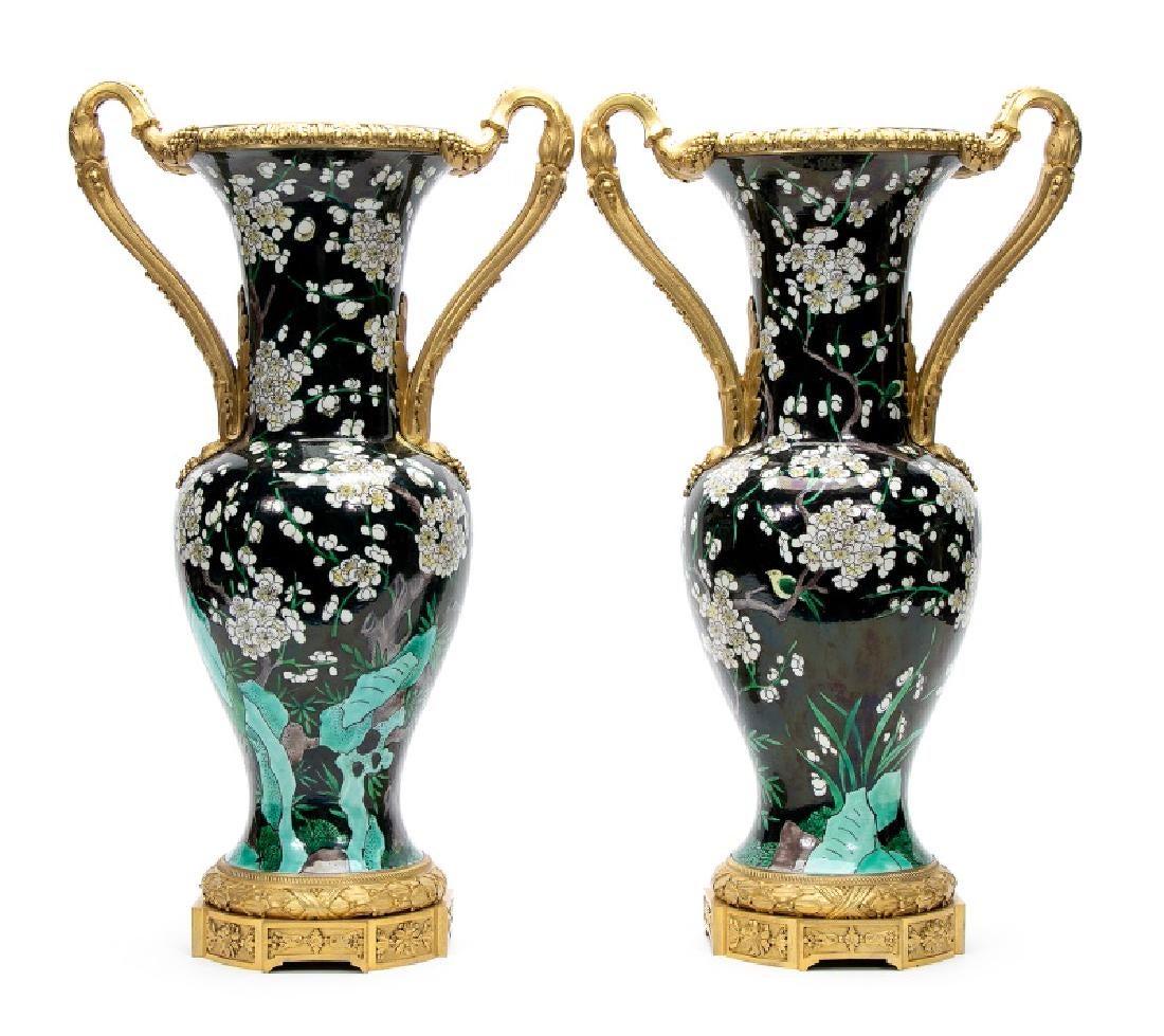 Late 19th century. Pair of French doré bronze mounted Chinese Famille Noir baluster form porcelain vases, decorated with a rockery base with white flowering plum trees against a black ground. Period French retailer's labels on bases. 20.25