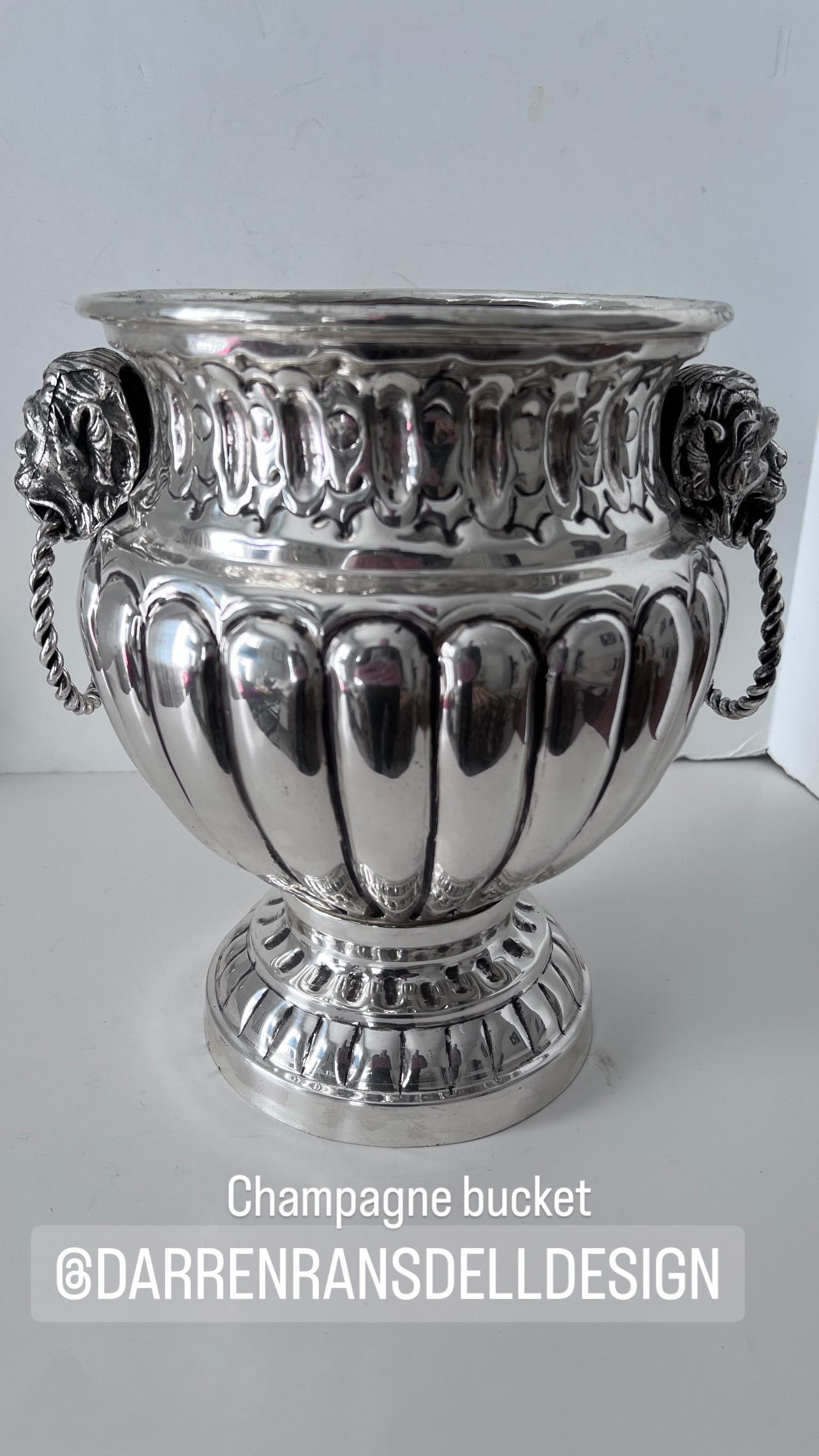 A Beautifully unique Dutch Silver Plate Champagne or Ice Bucket.  The piece is unlike any Champagne bucket we have seen.  The sides are Ribbed and and the top pierced with heavy detailed lion handles with twisted silver rings. The Bucket has a very