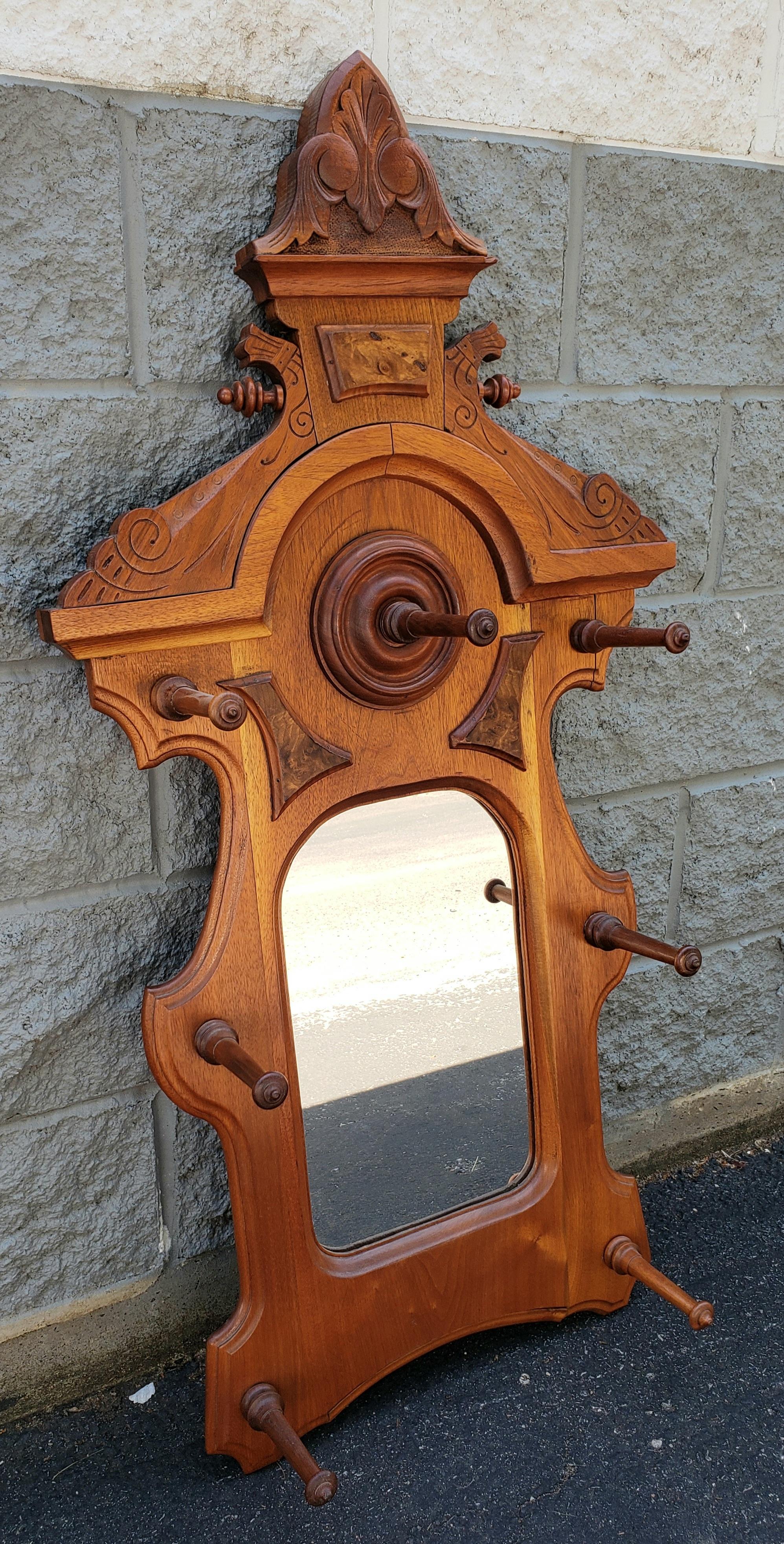 A 19th Century Eastlake Golden Oak handcrafted Rococo Style Coat and Hat Hanging Hall Mirror in good condition. Comes with 6 pegs for you hats or coats. Each peg is 5.75