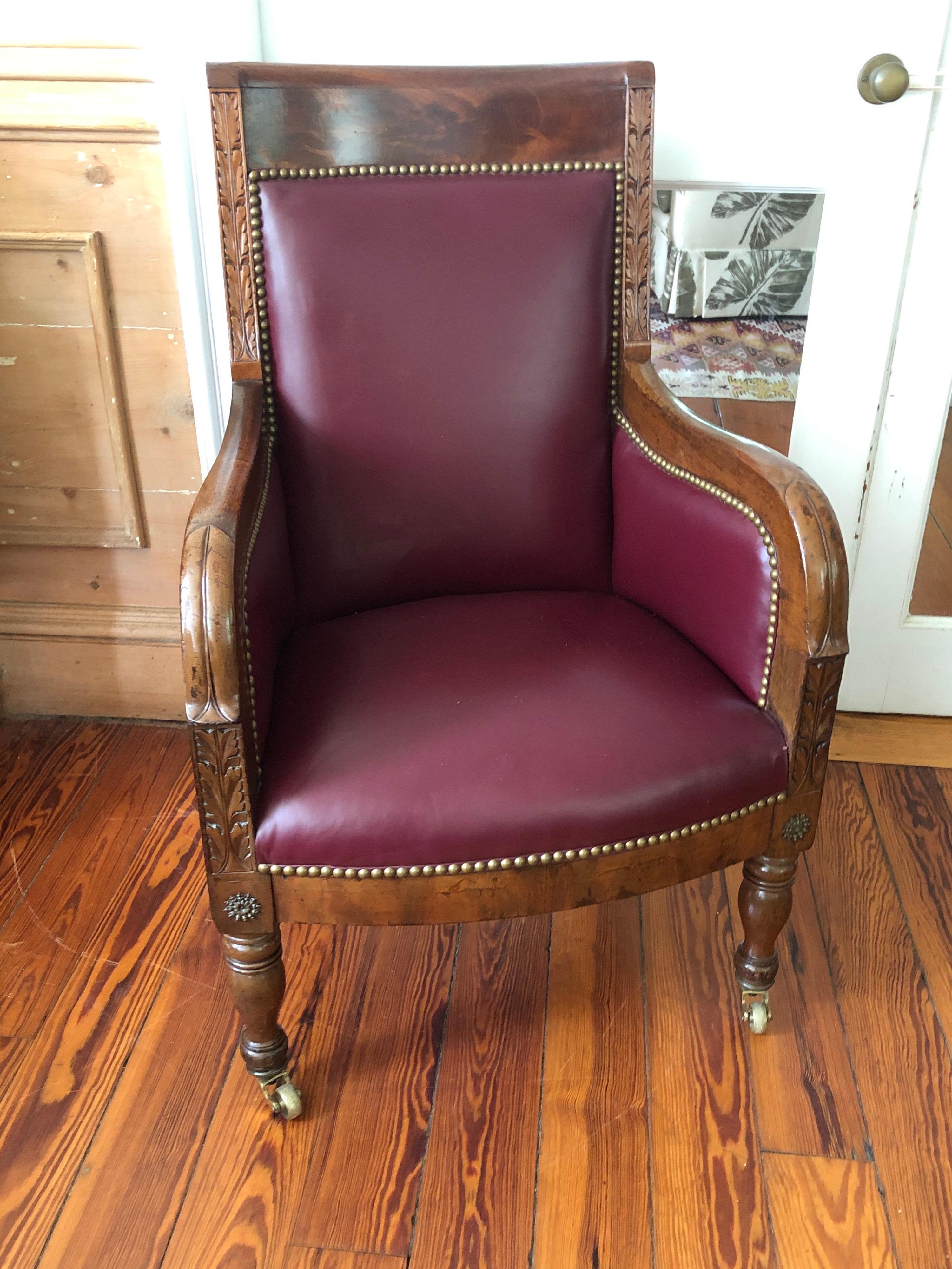 19th century Empire mahogany chair on brass casters. Upholstered in dark red
leatherette and finished with brass upholstery tacks.