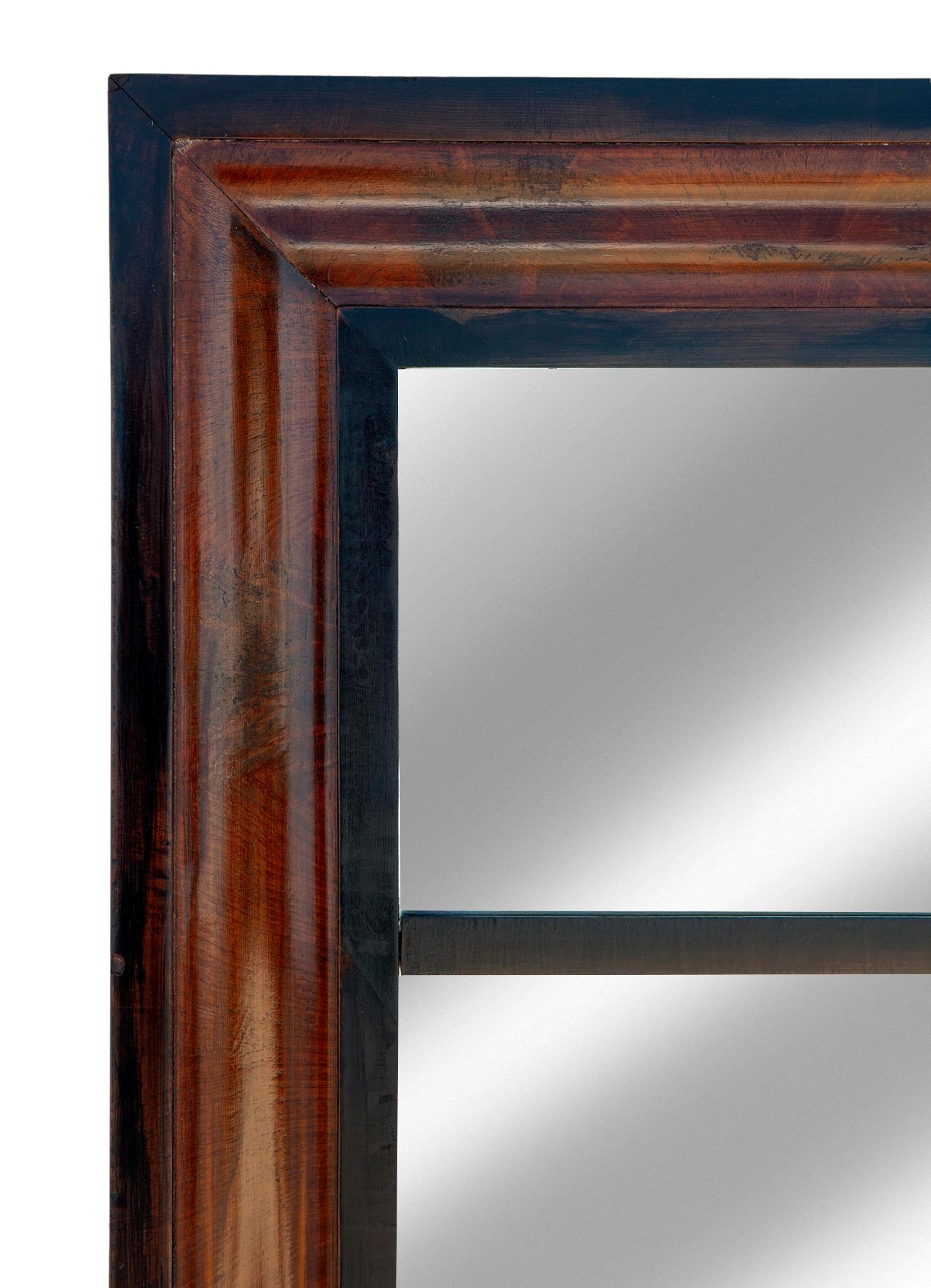 Empire Mahogany Trumeau Mirror in flame mahogany, circa early 19thC. 
Restored In ebony & polished mahogany. Classic Empire Traditional style, featuring upper & lower mirrored panes. The original wood backing is intact. 
