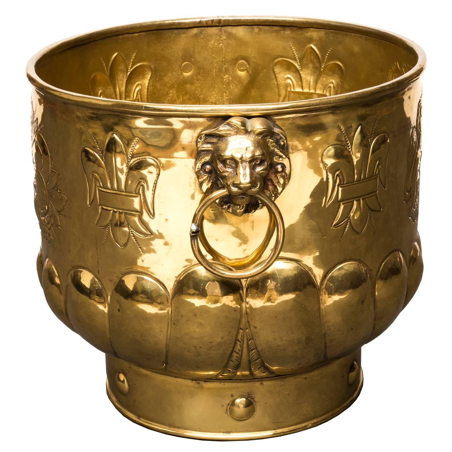 An English 19th century brass planter on copper. Hammered with the coat of arms and fleur dis lys. Lion face handles with rings. Professionally polished in England.