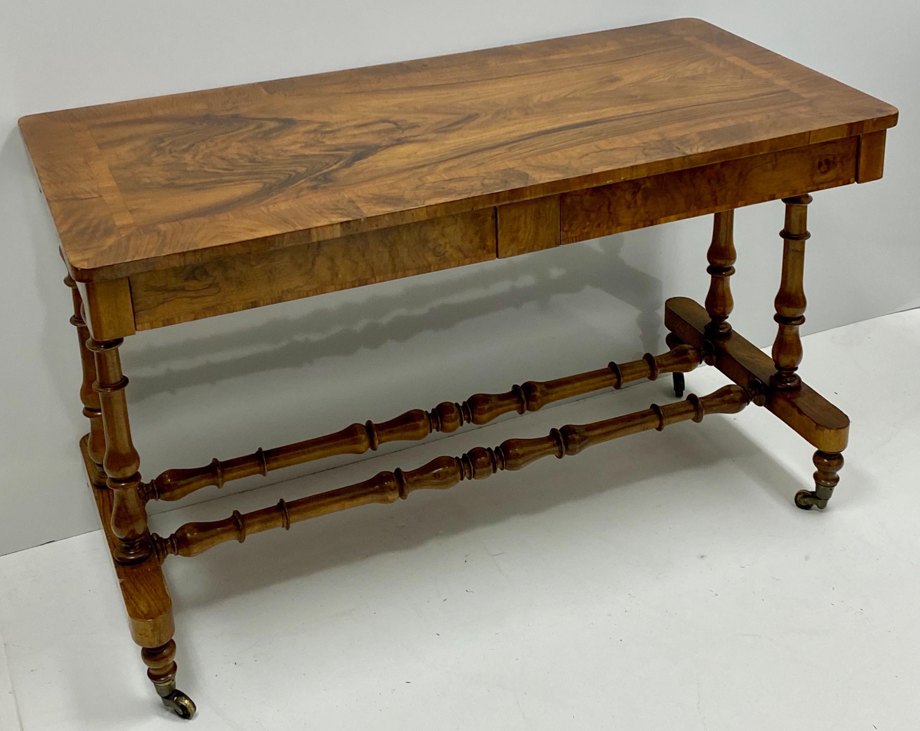 This is a late 19th century English carved walnut turned leg writing desk or console table. It is in very good condition, and the drawers do have dovetail construction. It is unmarked.