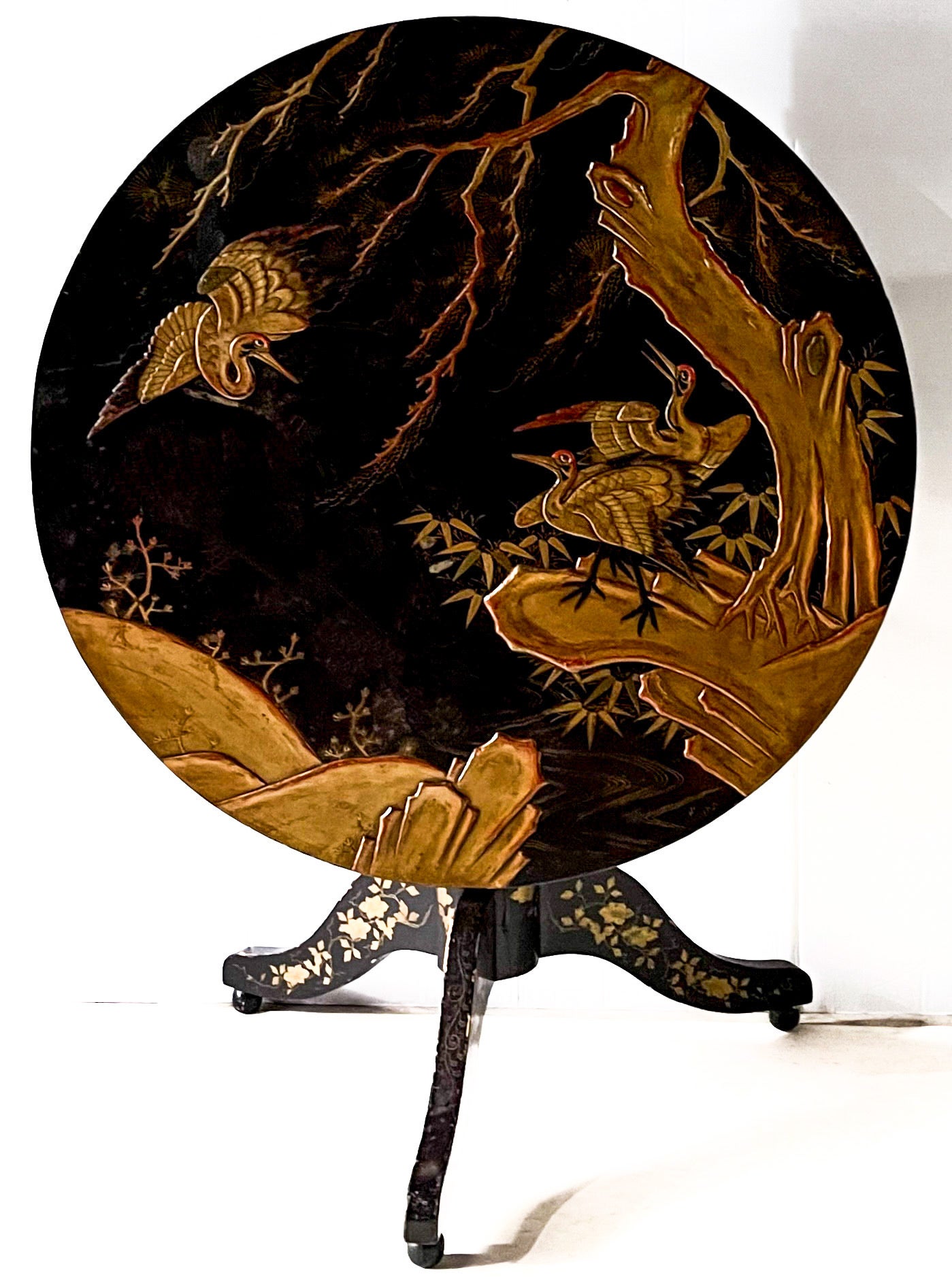 This is a special piece! It is a large scale ebonized tilt-top 19th century English chinoiserie table. It would work well as a dining or center table as it is fifty inches in diameter. The piece is japanned with cranes and foliage. The splayed