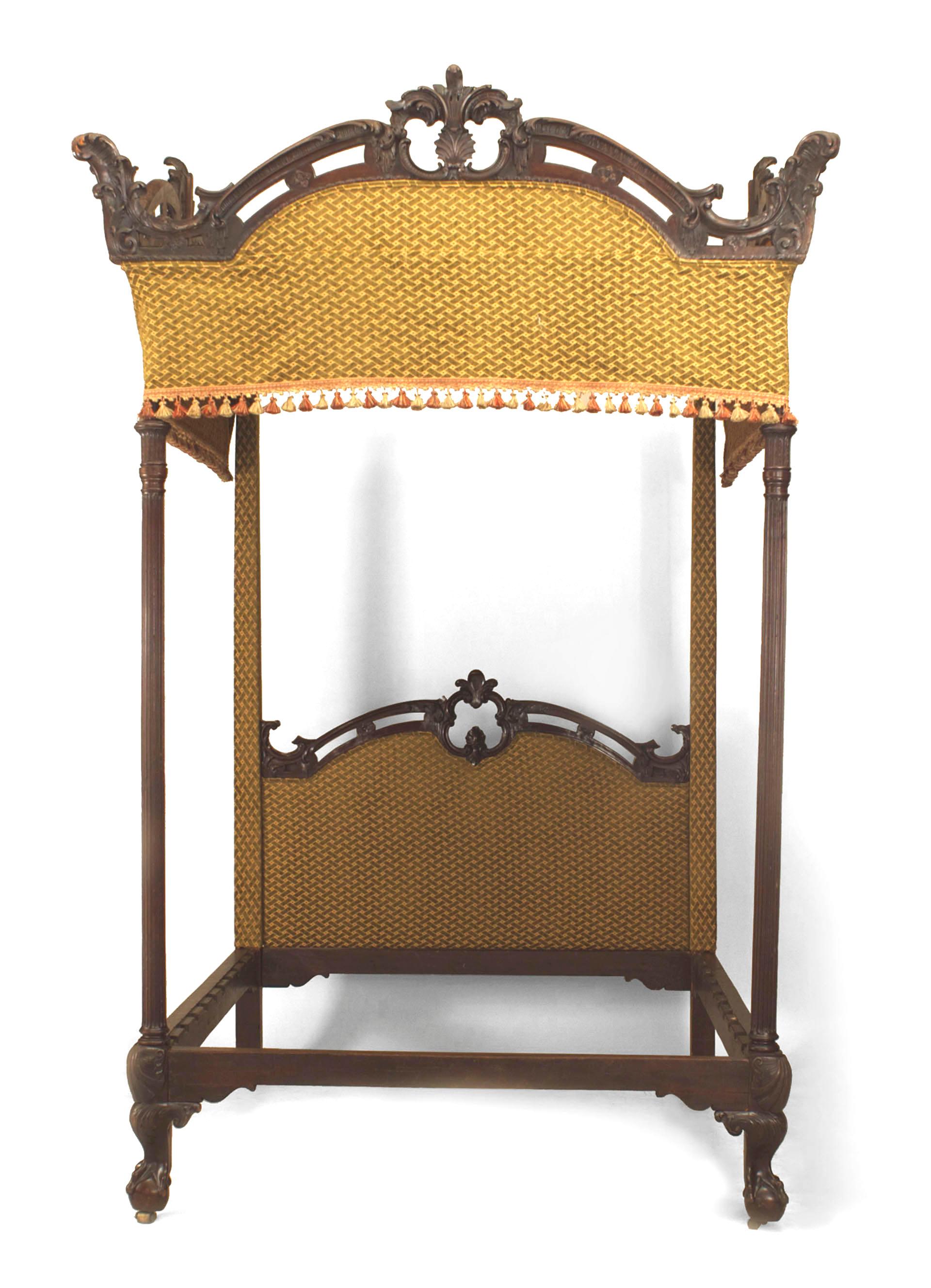 The mahogany bed featuring a pierced carved headboard and canopy supported by four turned and reeded posts all supported by carved ball and claw feet