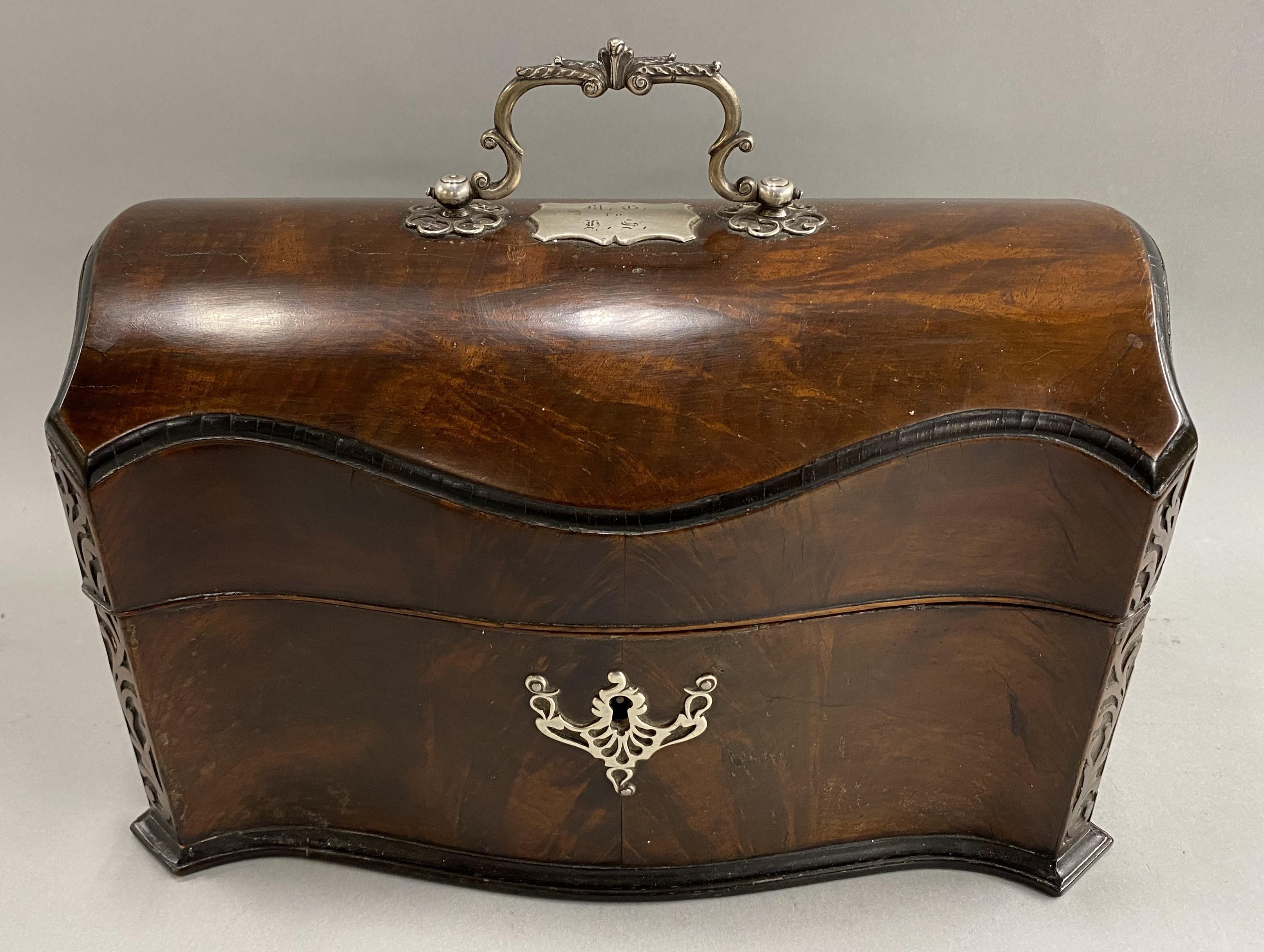A nicely carved English mahogany tea caddy in the Chippendale style with dome top and scroll carved corners, silver plate scrollwork escutcheon & handle, the custom interior lined with velour for silver plated tea boxes with acorn & oak leaf knops