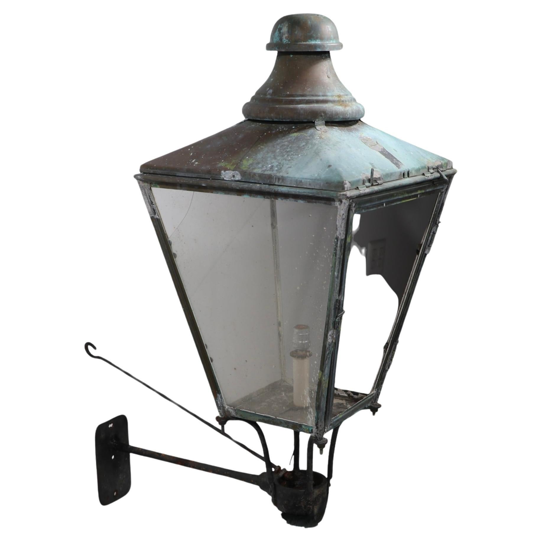 Rare English copper lantern sconce by noted maker, Foster & Pullen. The lantern has hinged top, and hinged panel door to allow access to the bulb from either the  top or the  front. The lid retains the makers tag which reads Foster & Pullen Limited