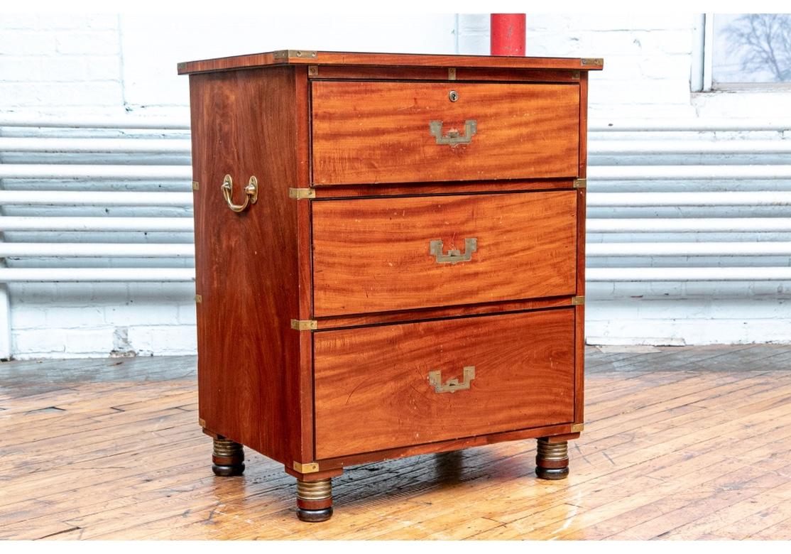 Three long graduated drawers mounted with twin brass carry handles, the Classic enclosed handles and corner mounts. Raised on brass ring turned feet. Lacking a key for the top drawer.
Measures: 25.5” wide by 19.25” deep by 32” high.
Condition: the