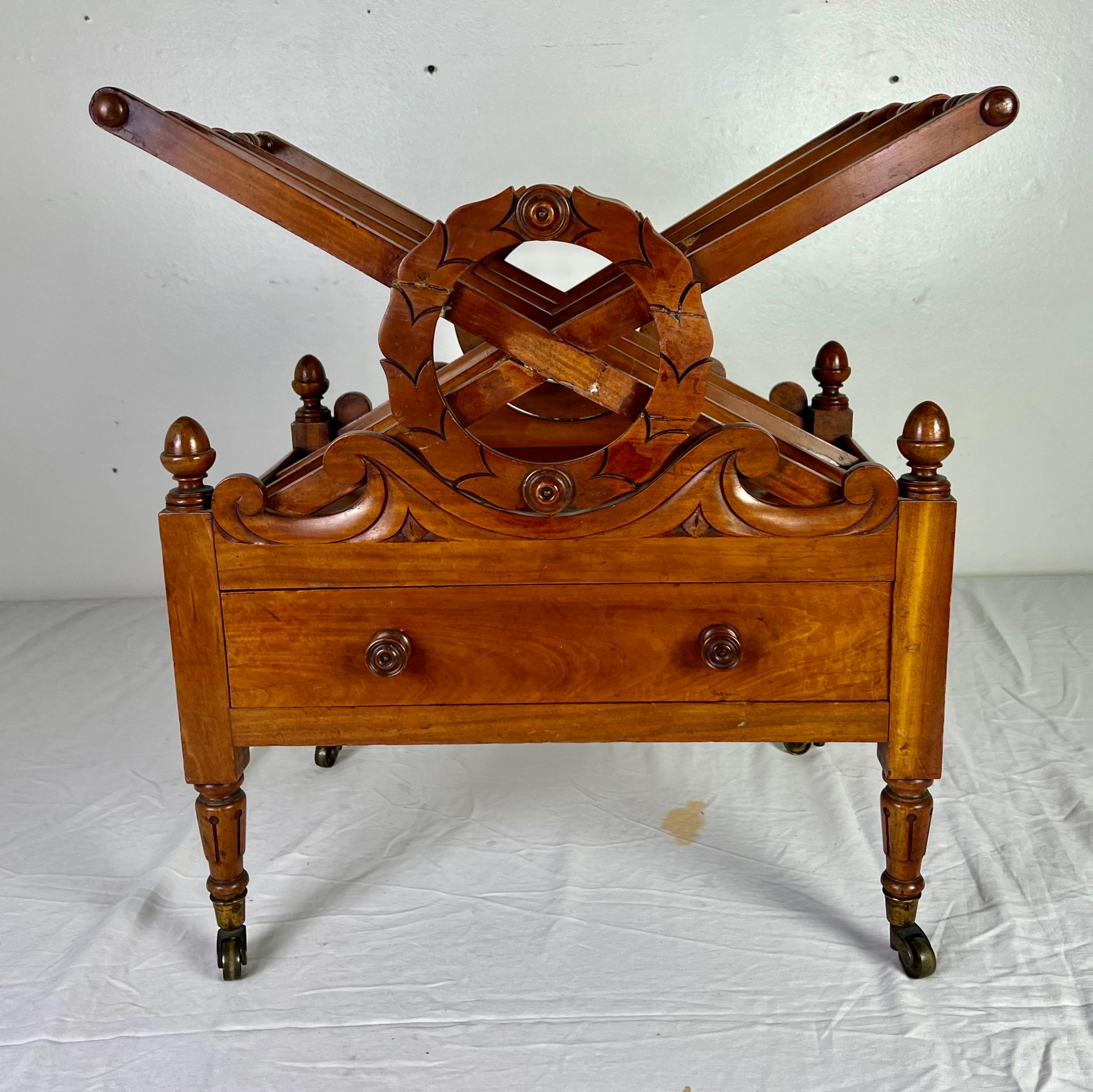 19th century English maple magazine rack with single drawer.  The magazine rack stands on four straight legs that have the original casters.