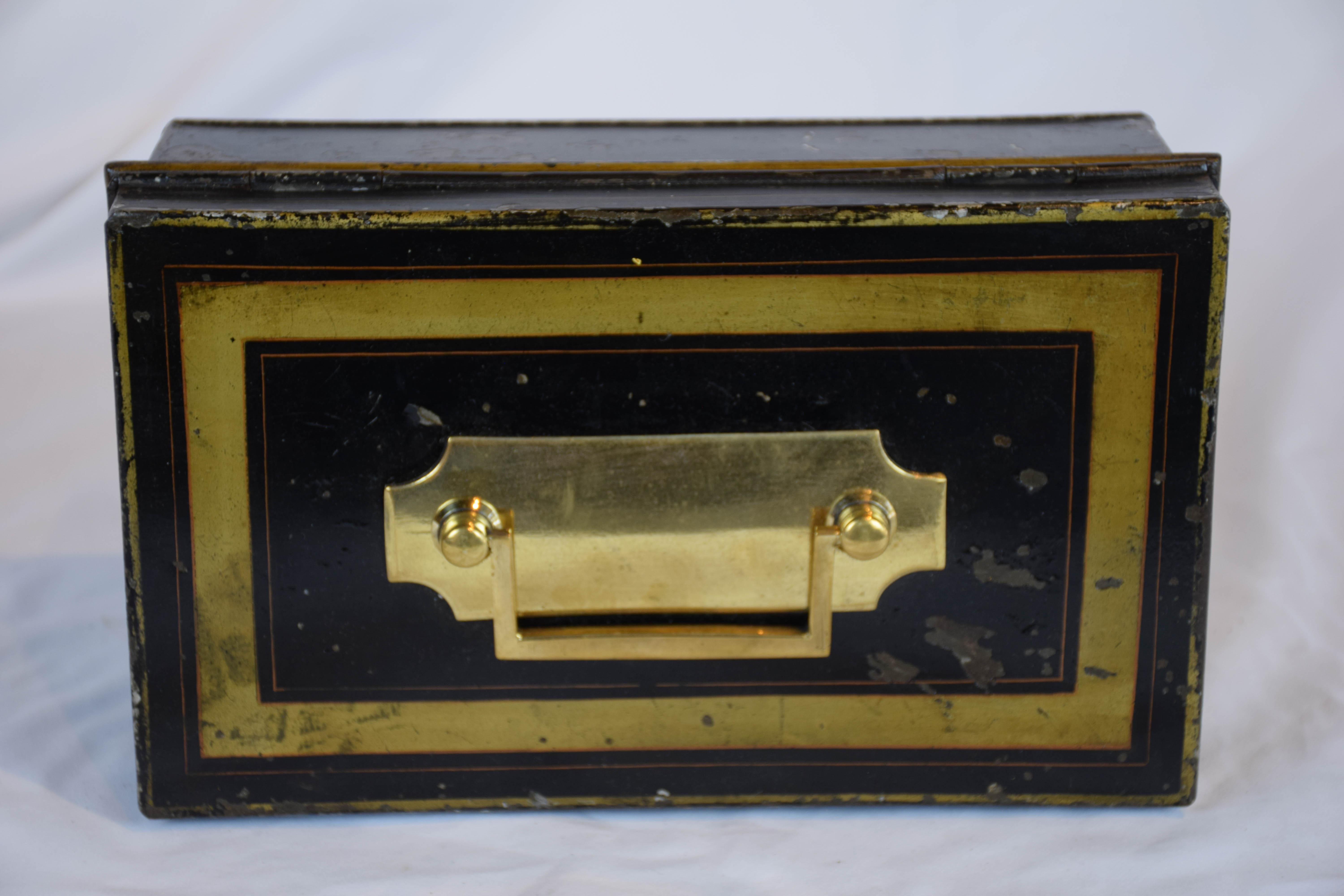 This 19th century English cash box is all original. The box when open has an insert with 2 compartments with hinged lids and a handle. The box has a key, however we couldn't get it to turn in the lock. Beautiful original paint in black and gold.