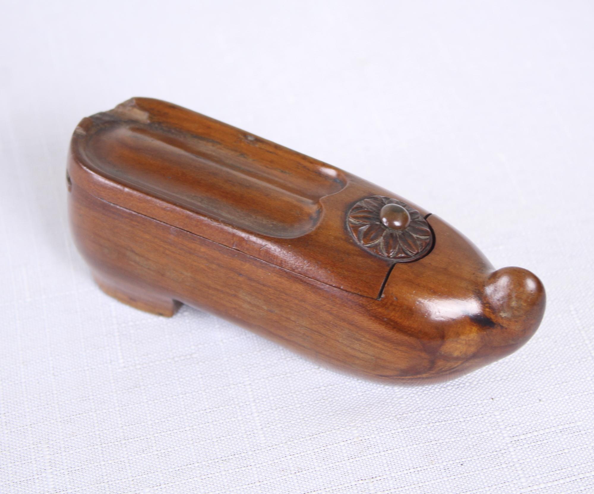 Novelty carved snuff box in the form of a shoe. Opening sliding top with decorative carved roundel. Slight chip on the back, but otherwise in good condition. Lovely color and patina. We believe it to be fashioned of mahogany.