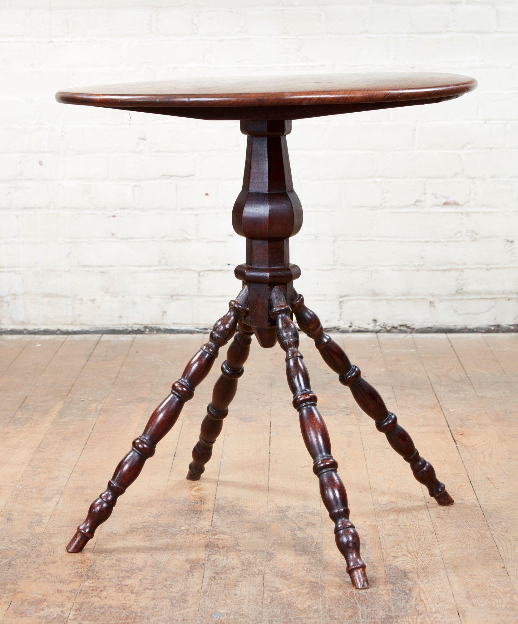 A unique 19th century English spindle table perfect for a drinks table next to the arm of a sofa. Nicely figured elm top on faceted column shaft ending in four bobbin turned legs. Striking and distinctive profile and rich patination.