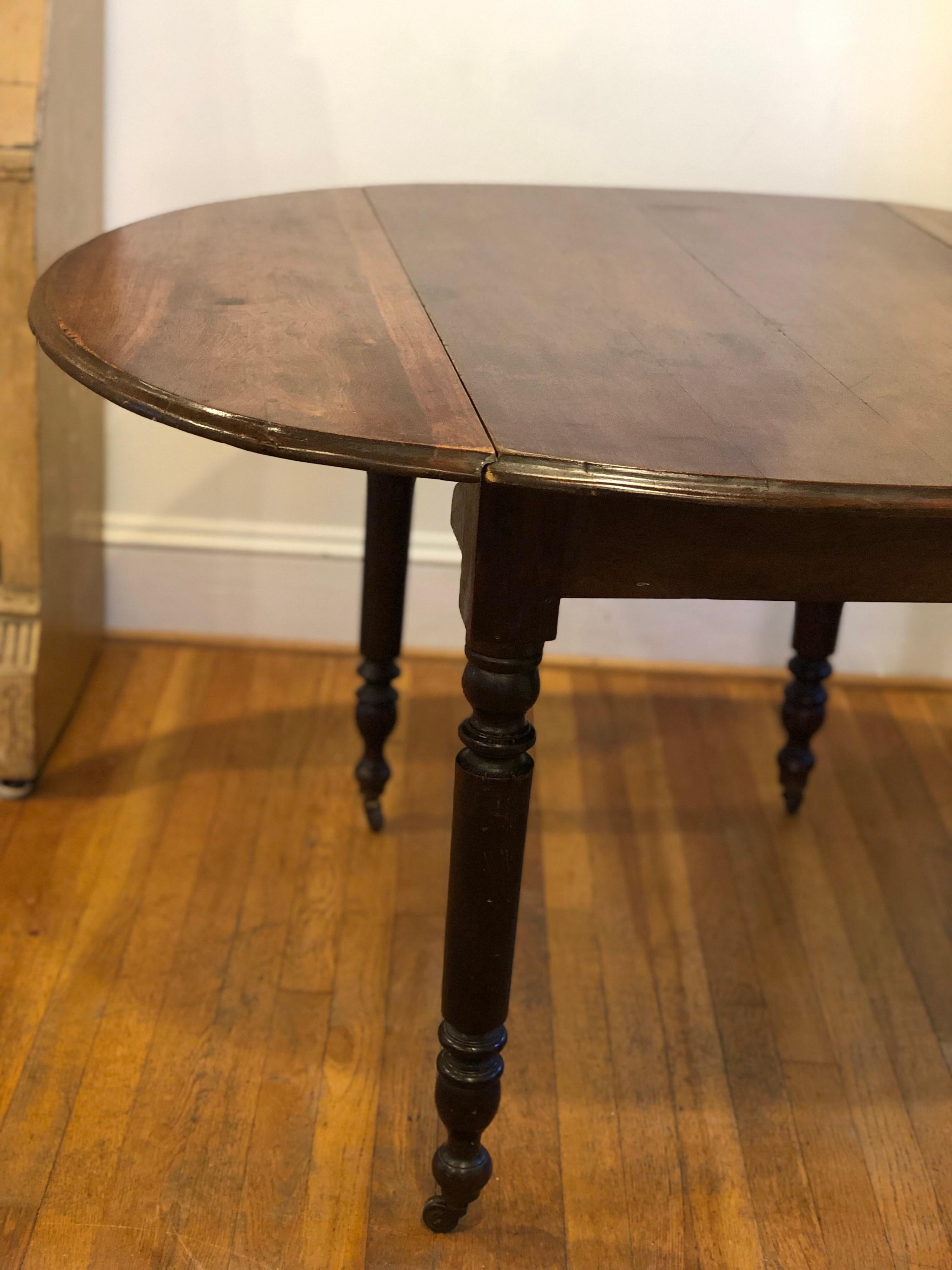 A beautiful example of early English walnut furniture with lovely color, beautiful ageing and with centre panel two drop leaves and fold out arms. Each turned leg has original castor on the feet.

Table is in overall good used condition for age