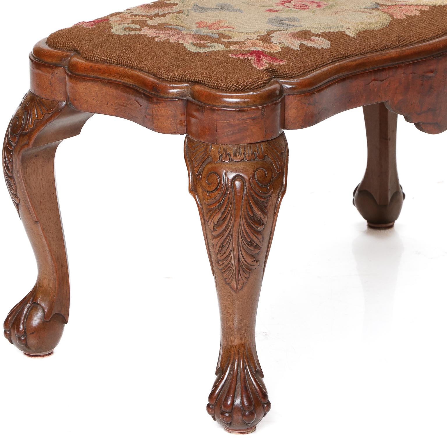 19th C. English walnut foot stool with drop-in tapestry covered seat, serpentine shaped on all sides, apron shaped with frieze, and resting on cabriole legs with acanthus carved knees and ball and claw feet, C. 1860. 

Measures: 26