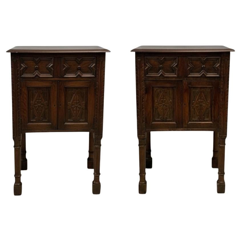 This is a pair of 19th century English carved oak cabinets or side tables with William and Mary styling. They have a single drawer over two doors. The panels are all carved and they have block legs. Each cabinet has age appropriate wear.