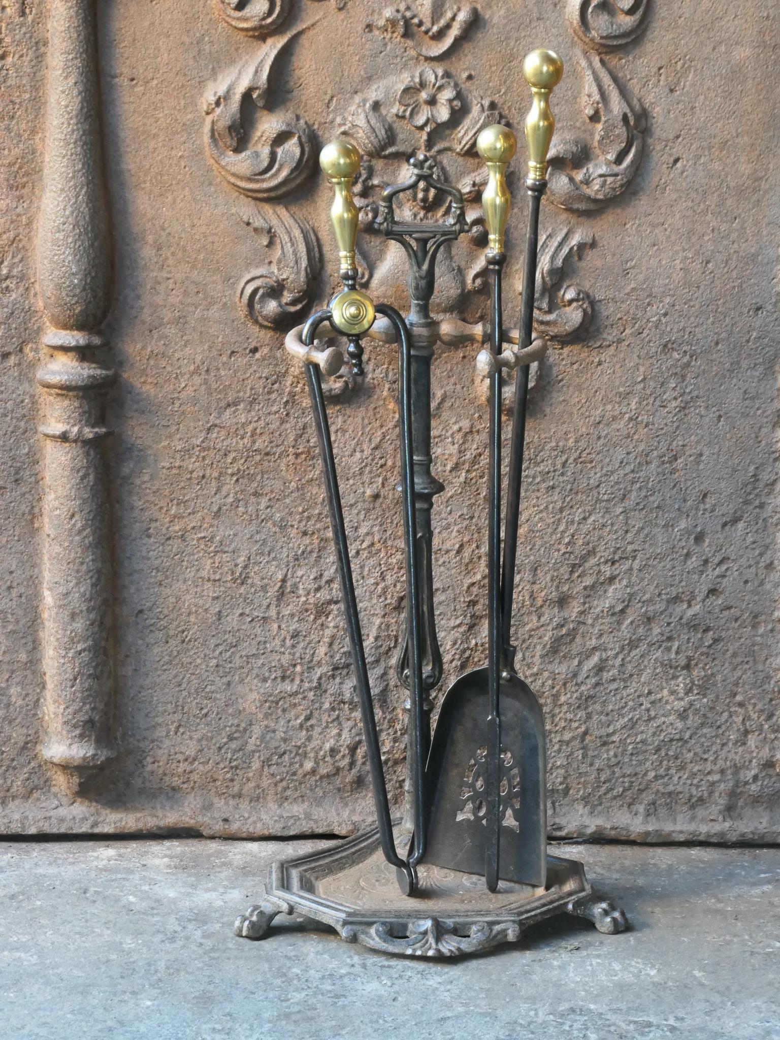 19th Century English Victorian period fireplace tool set. The tool set consists of thongs, shovel, poker and stand. Made of wrought iron, brass and polished brass. It is in a good condition and is fully functional.