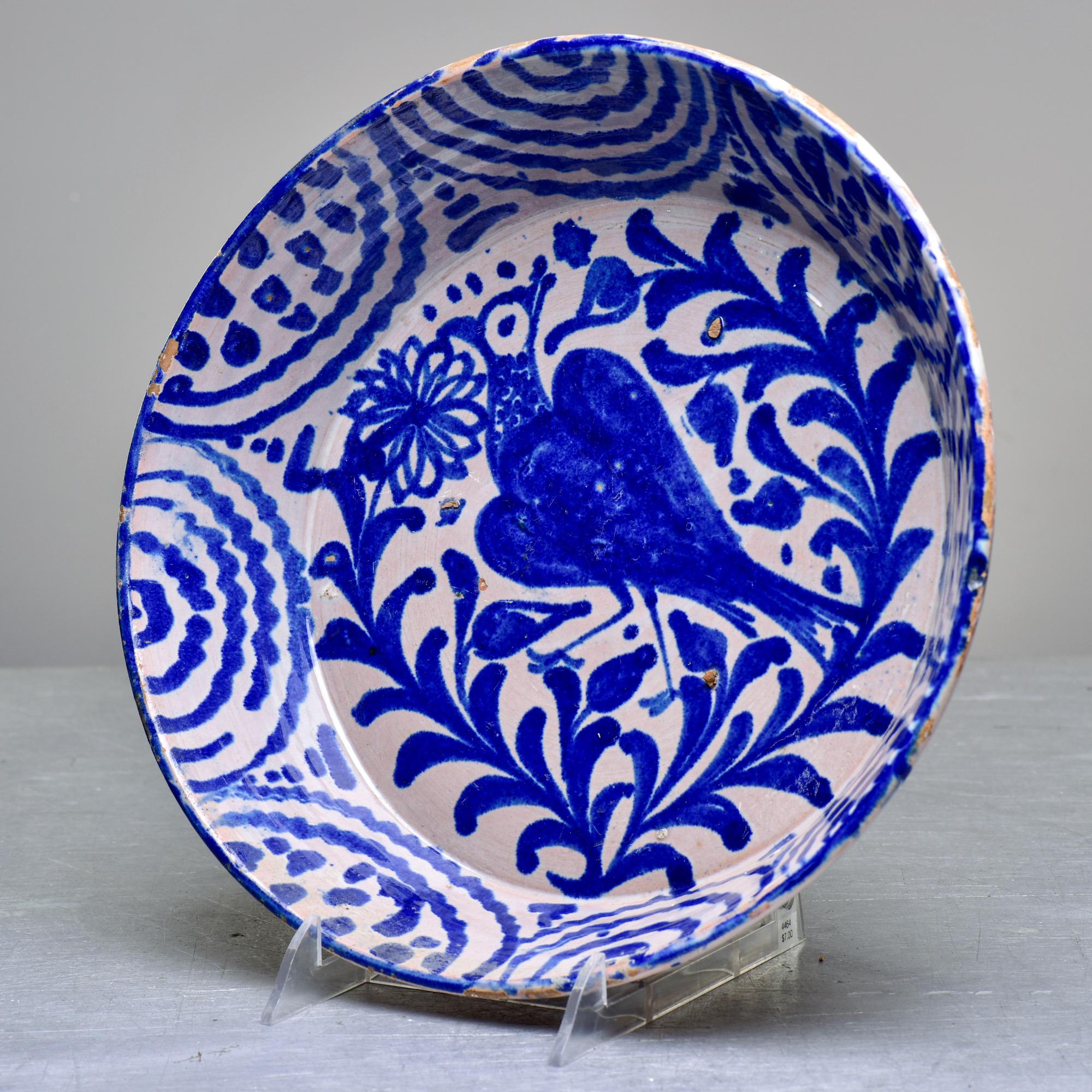 Circa 1890s Spanish Fajalauza terra cotta bowl in traditional blue and white glaze with bird at the center and scalloped design at the border. Fajalauza pottery is from Granada, Spain and originated during the 13-15th centuries when the Nasrid