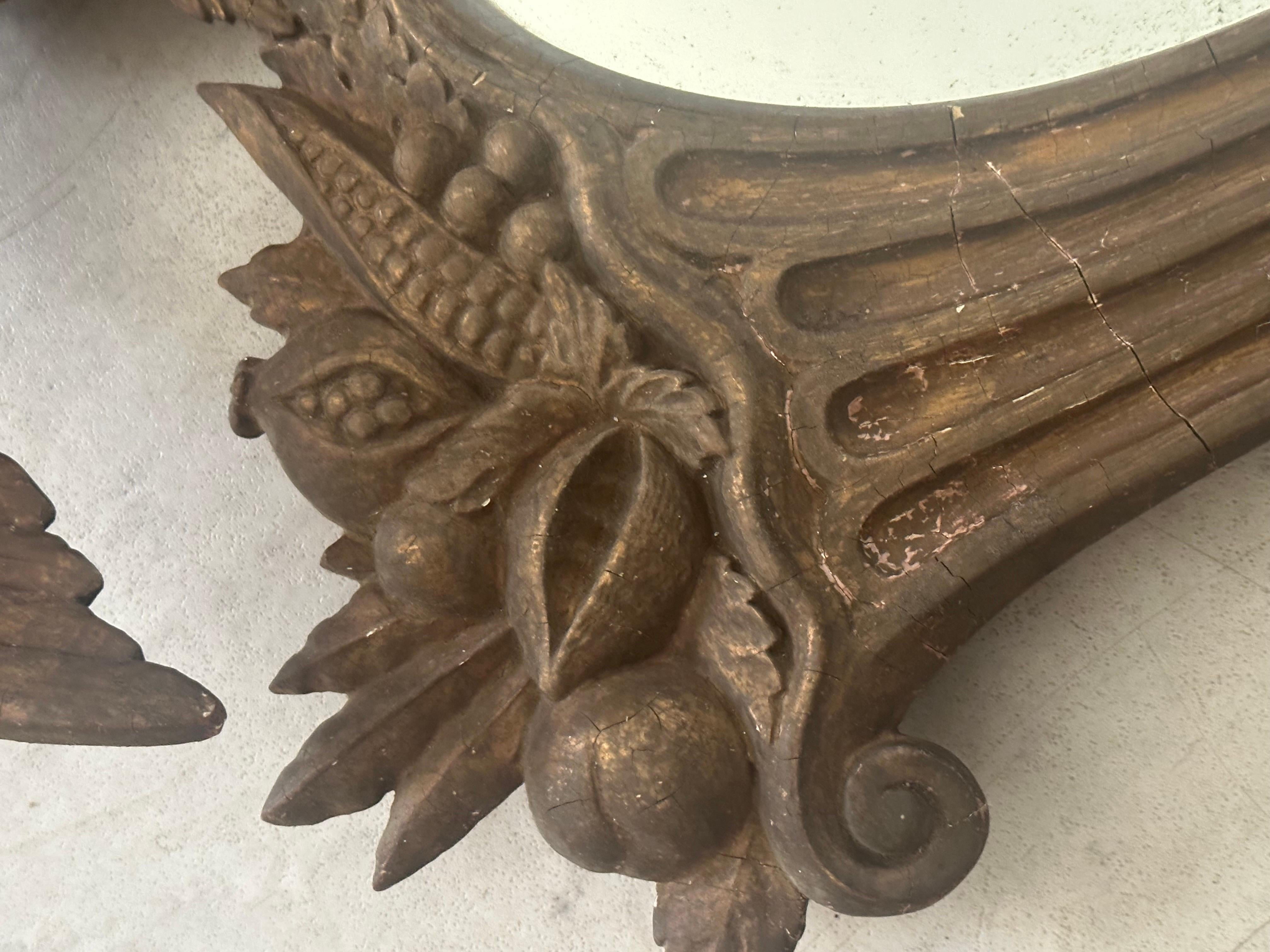 19th century federal style mirror, hand carved and intact, two cornucopias filled flanking either side of the eagle. 

Classic design element of the federal period (much like the convex mirror but without the distorted mirror)
