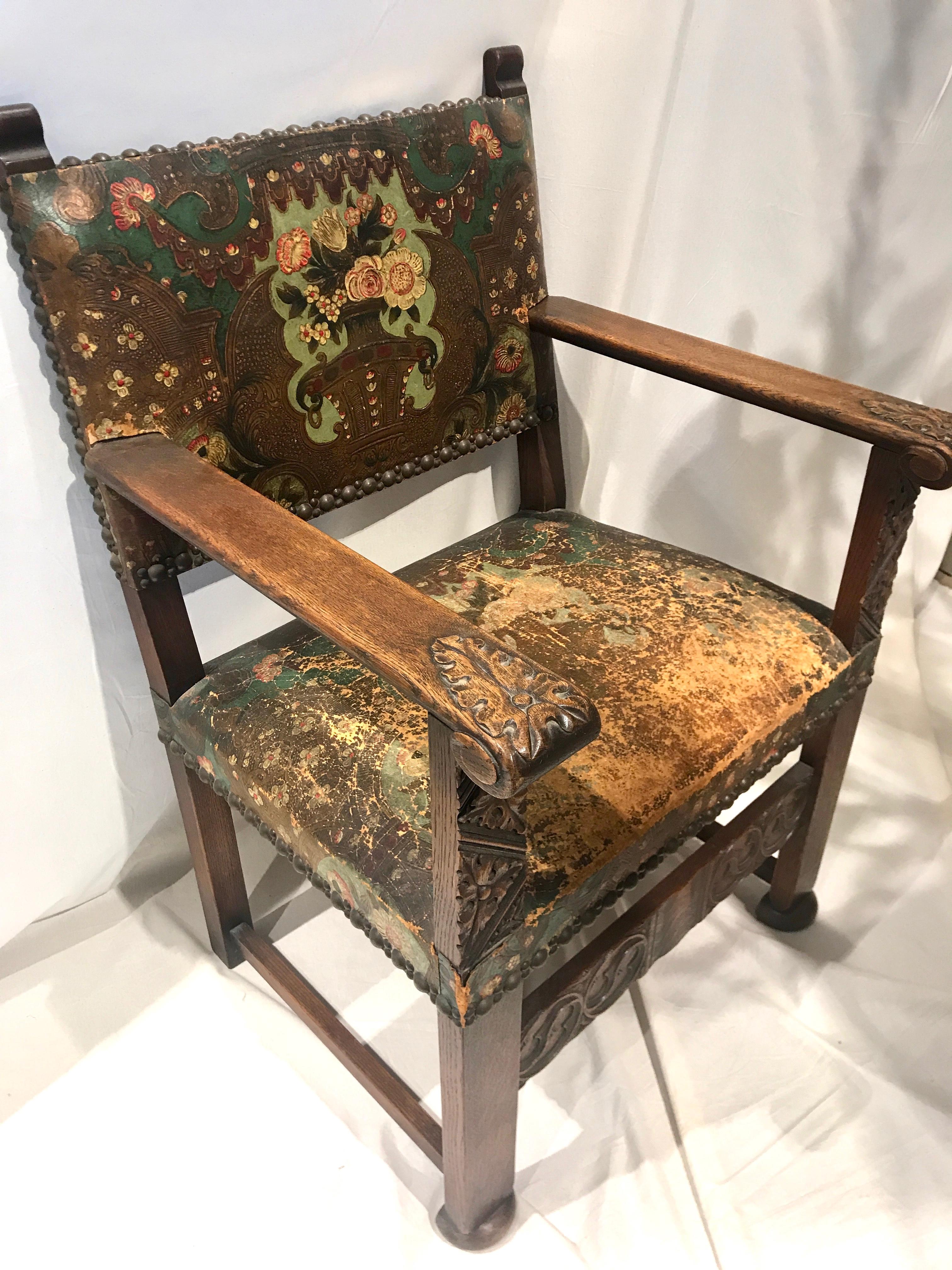 19th century Flemish oak armchair retaining the original hand embossed and painted Mechelen leather upholstery. The leather is painted in lovely shades of gold and turquoise on an embossed design of a floral vase and tasseled swag curtains. The