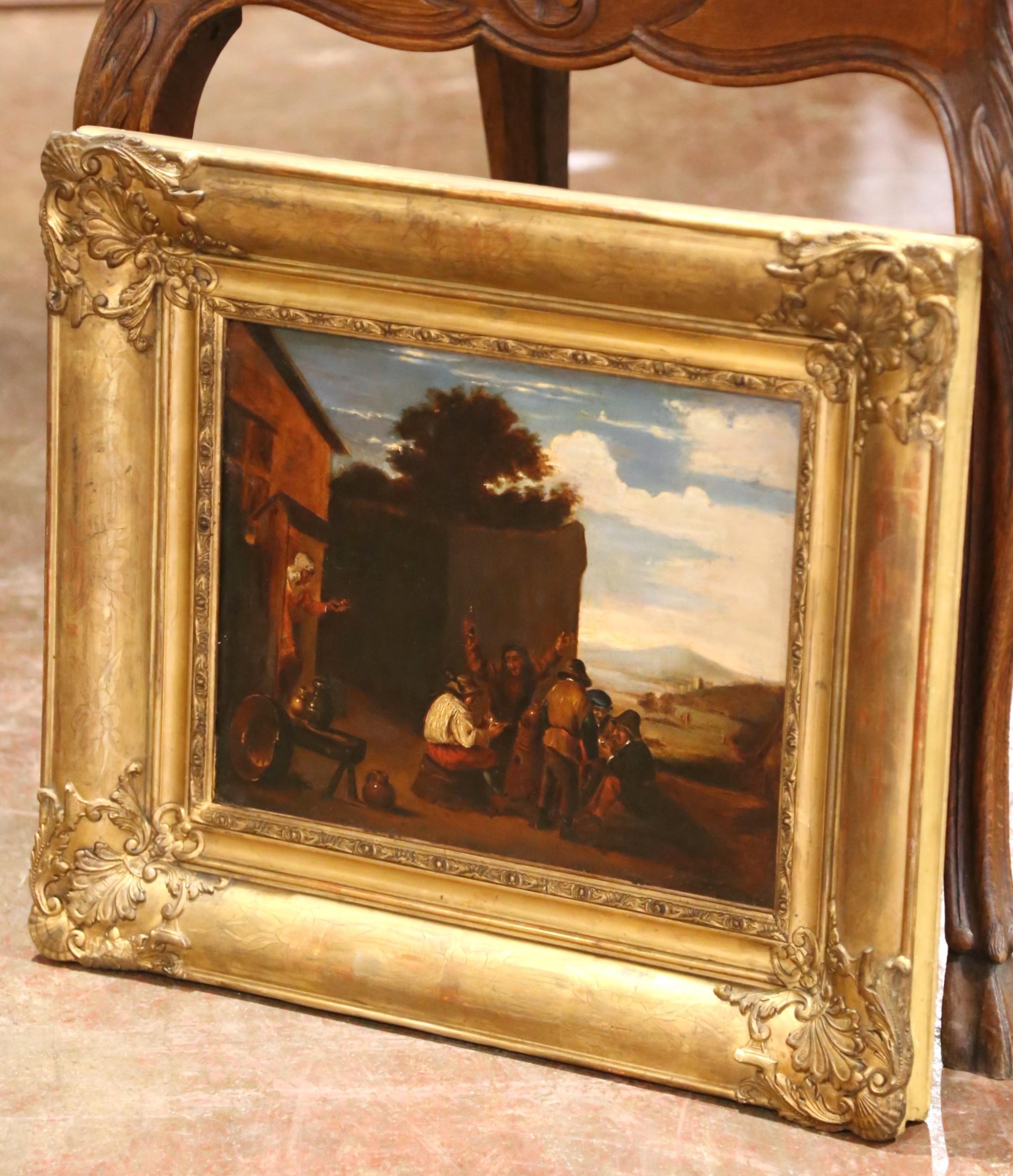 Painted in Belgium circa 1860, this richly detailed 19th-century oil on canvas depicts a lively outdoor tavern scene rendered in the Flemish tradition, in the manner of David Teniers the Younger. A group of peasants animatedly converses and drinks