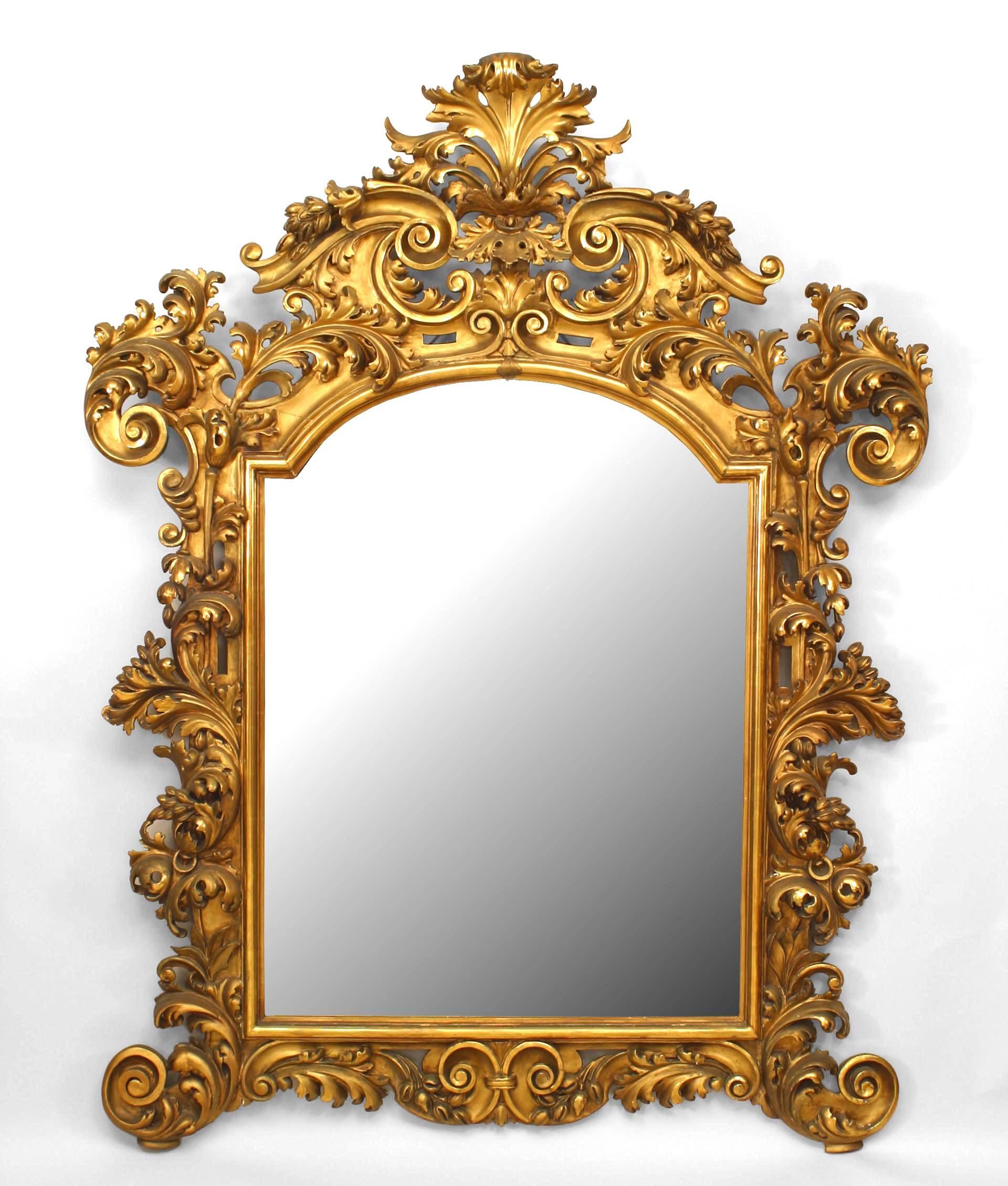 Italian Rococo (Florentine, 19th Century) giltwood wall mirror with extensive foliate carved filigree frame with a shell form pediment top.
