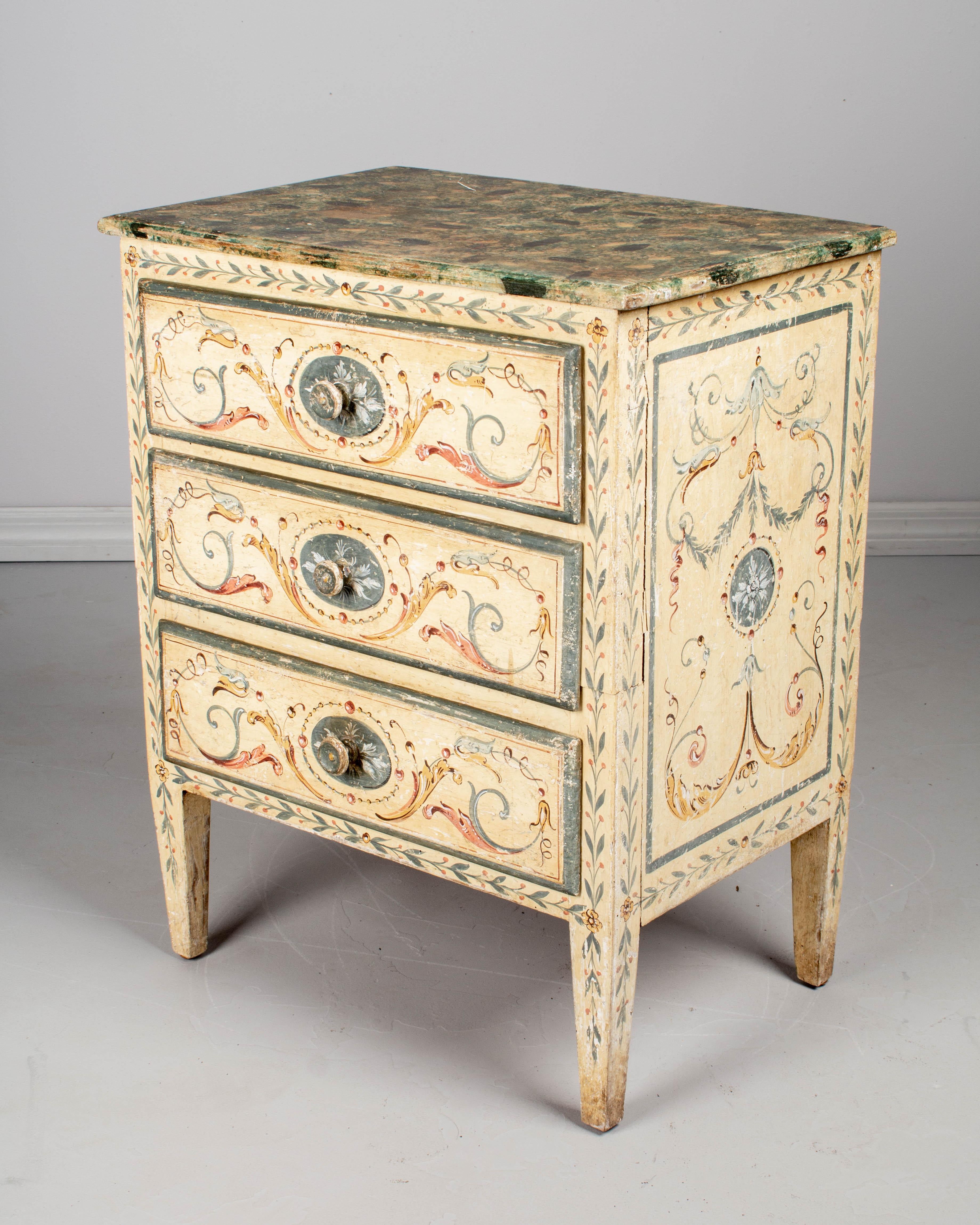 A small Italian Florentine style paint decorated chest, or nightstand. Made of pine, with three dovetailed drawers. Mid-19th century with later paint. In good condition, sturdy and well-crafted. Nice patina with minor paint loss. Please refer to