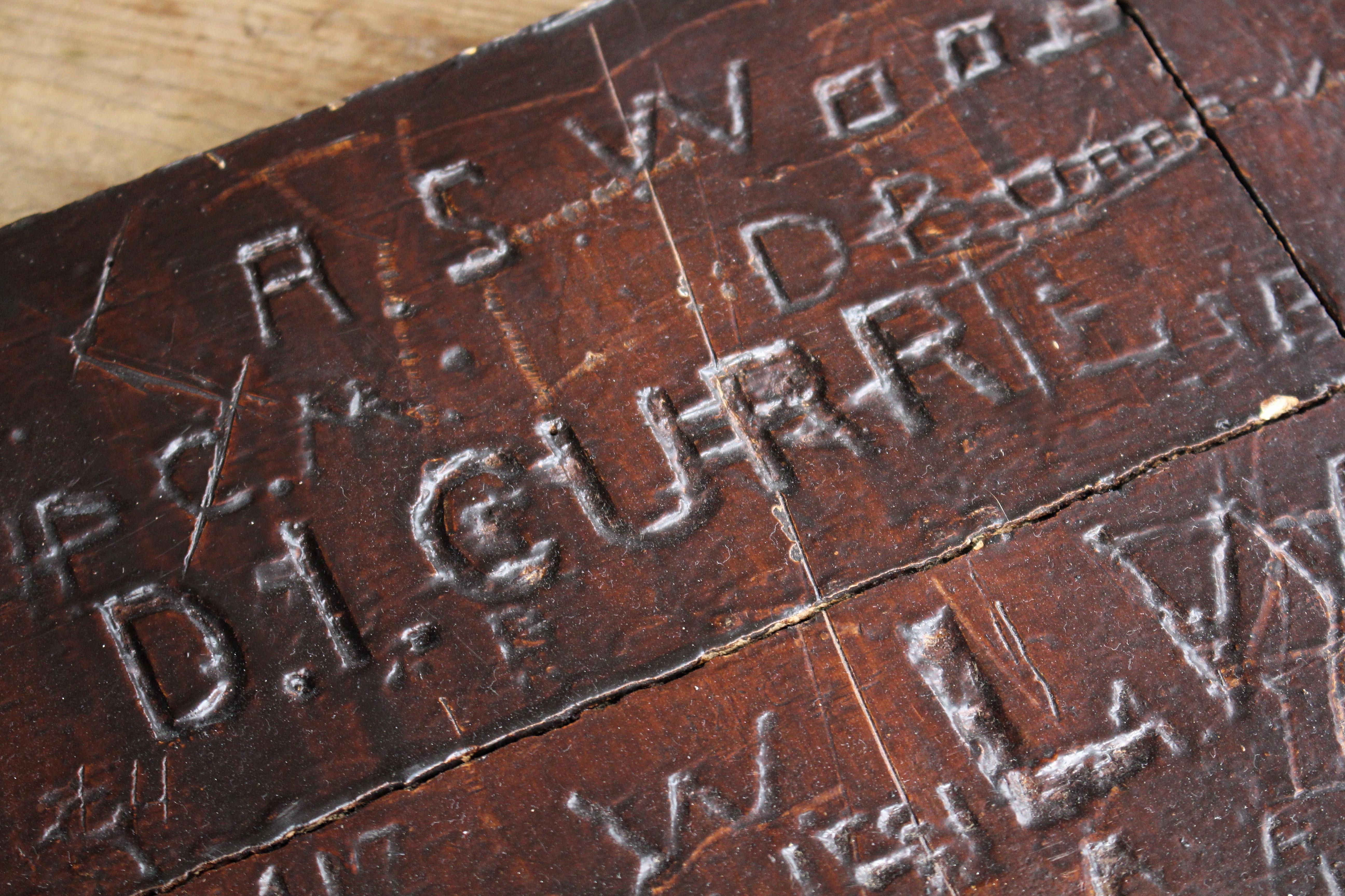 A profusely carved graffitied oak panel, possibly from a students desk, door or panel in a communal area like a toilet . The graffiti is mainly students names, with a later engraved silver plaque reading “Leeds Grammar School Founded 1552”.

“D.I.