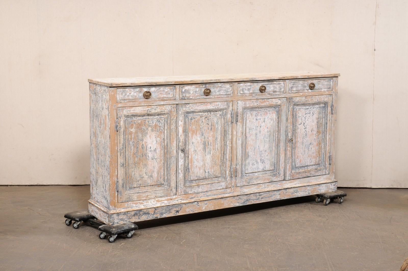 Una credenza francese a pannelli rialzati, con finitura scrostata, del XIX secolo. Questa antica consolle da buffet francese ha un piano di forma rettangolare che ospita quattro cassetti con pannello frontale rialzato (disposti orizzontalmente lungo