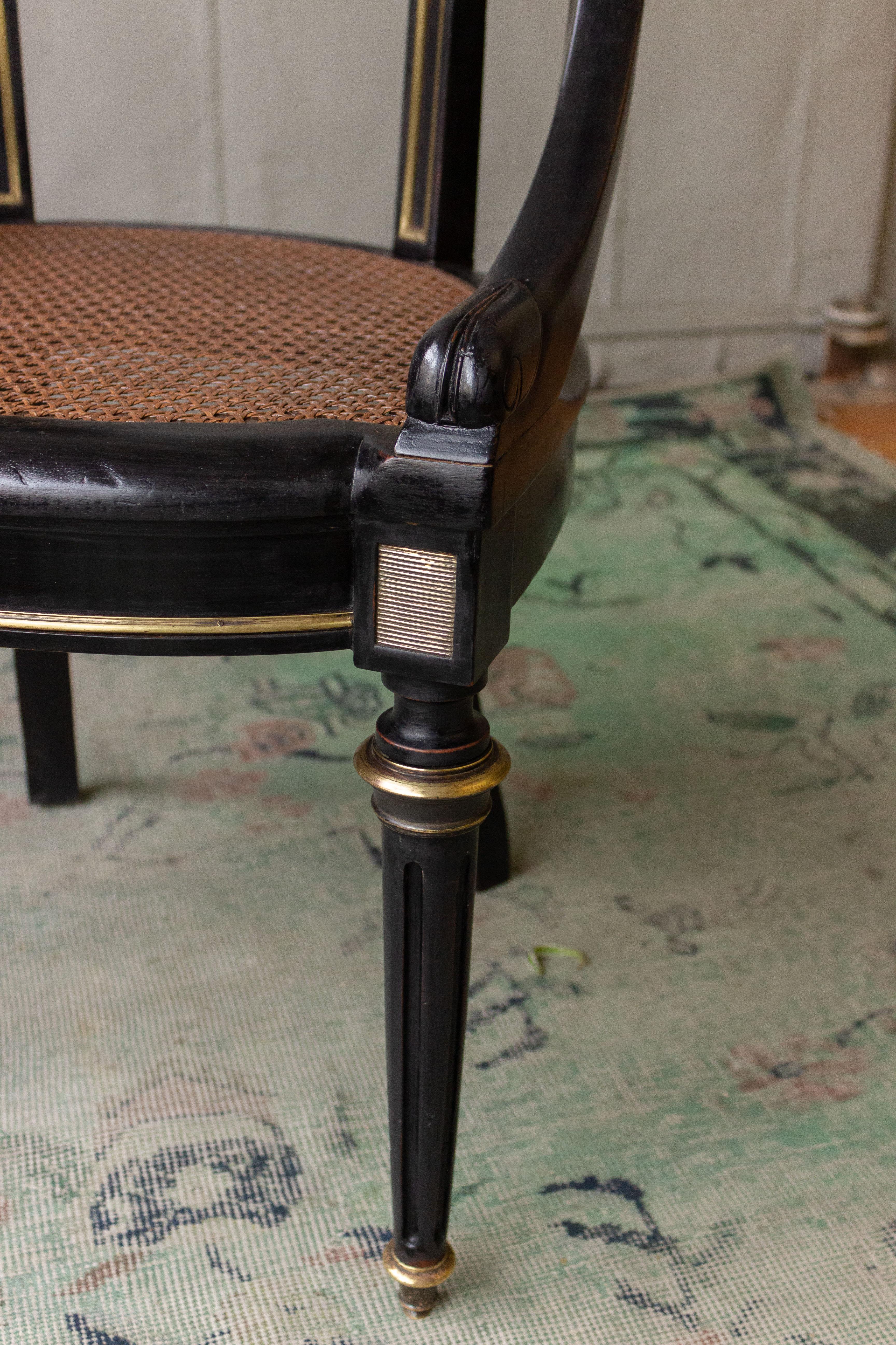 Ebonized armchair  with brass trim details. The front legs are fluted in the Louis XVI style and mounted on brass sabots. The caned seat is new and in excellent condition. French circa 1900.
