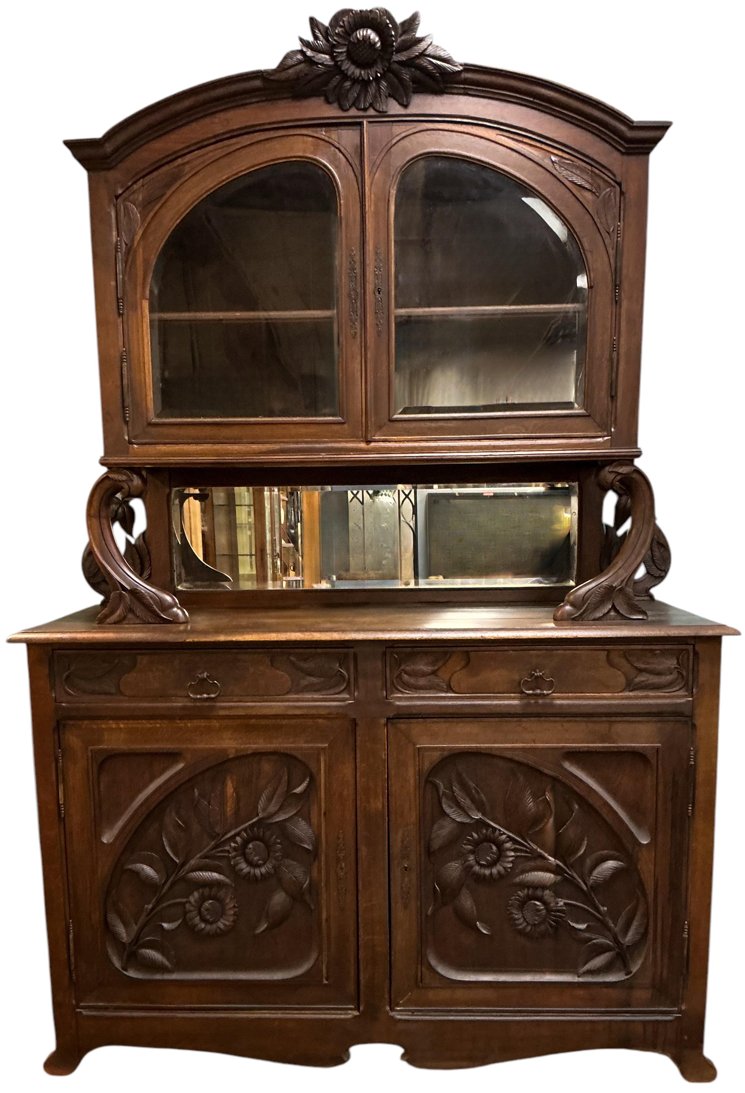Se trata de un mueble de porcelana Art Nouveau francés de roble tallado de finales del siglo XIX. Tiene un maravilloso follaje nervudo y flores que enmarcan los lados, con un tema repetido en los frentes de las puertas y el frontón. La parte