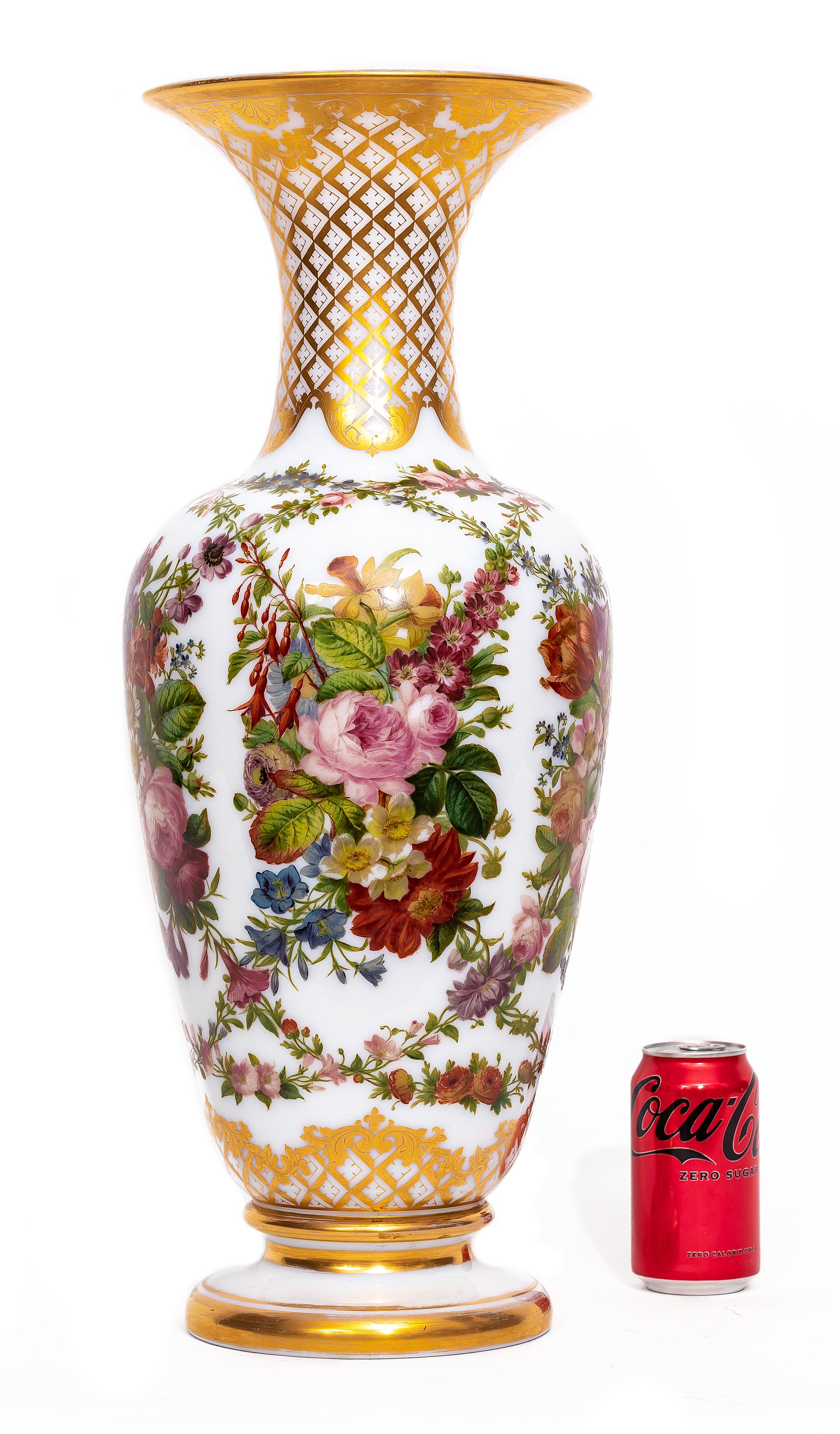Vase en cristal opalin de Baccarat du XIXe siècle, avec décoration florale émaillée à la main et rehauts de dorure.  Ce vase de forme balustre présente un col en forme de trompette, des épaules arrondies et un pied circulaire, le tout exécuté en