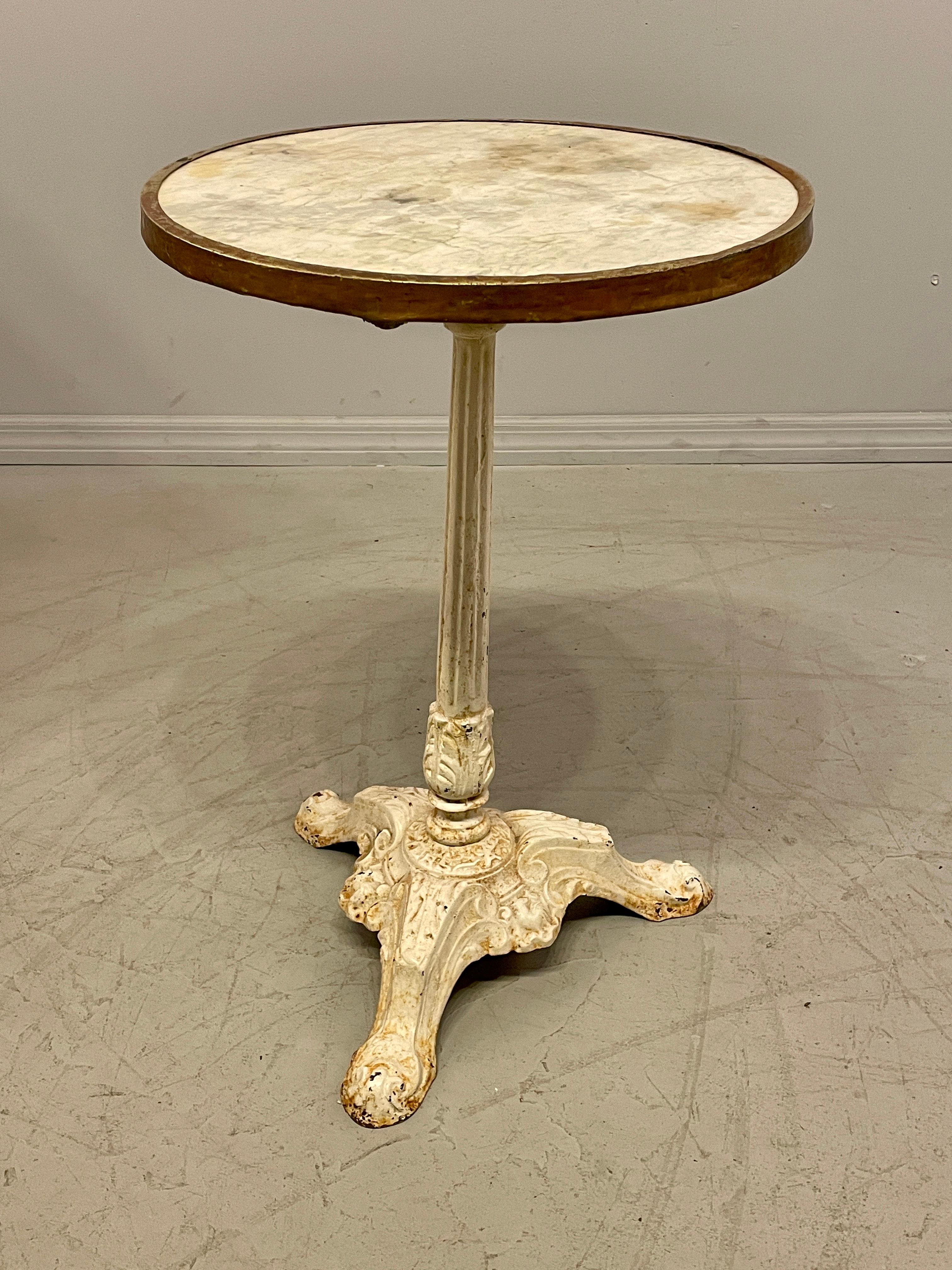 A 19th century French heavy cast iron bistro table. White marble top with brass band around the perimeter. Beautiful patina. All original. Circa 1870-1890  28