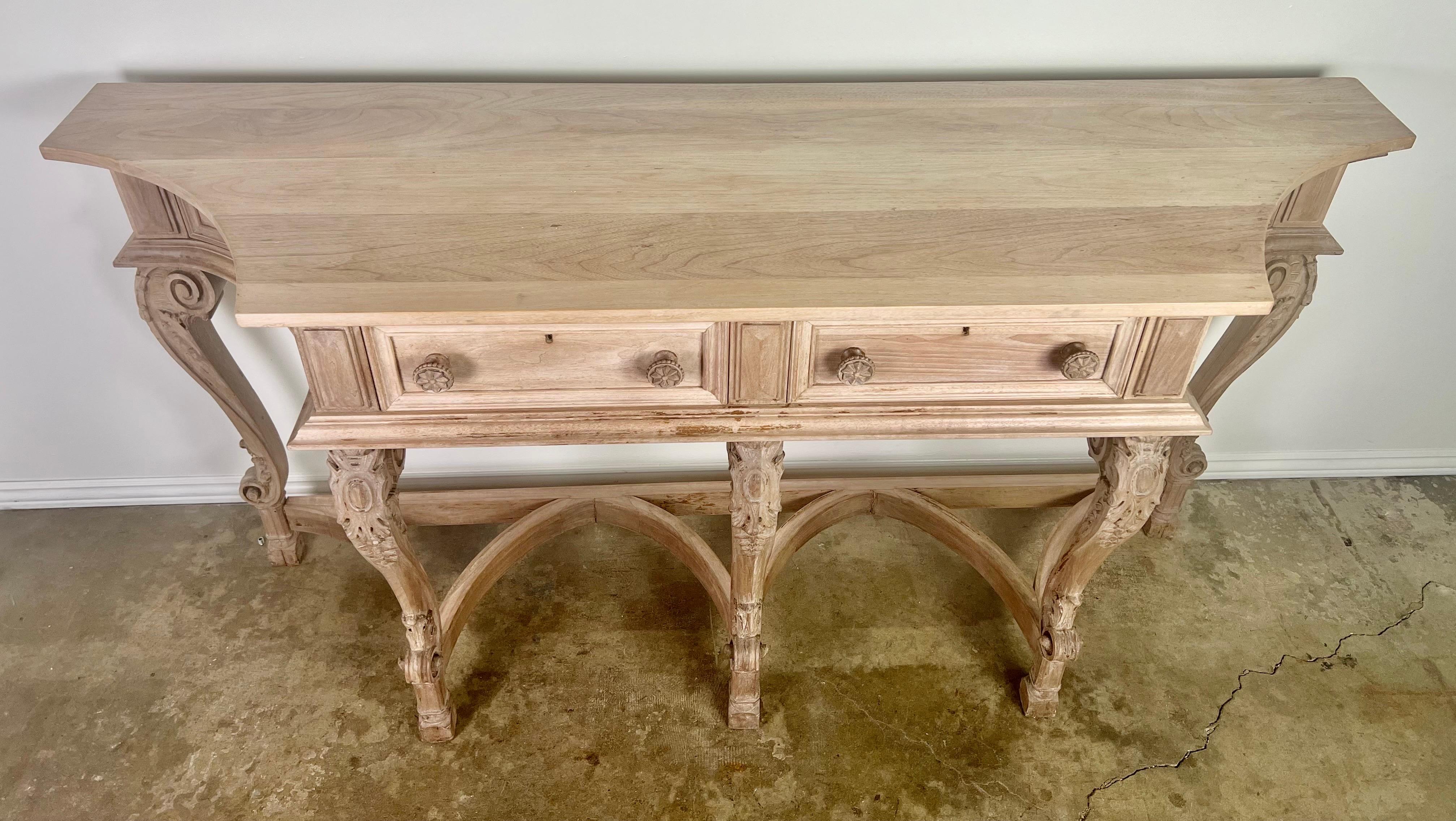 19th Century. French carved wood bleached walnut buffet. The buffet stands on five cabriole legs with rams head feet. A scalloped stretcher connects the legs at center. The console has carved acanthus leaves and beautiful cartouche carvings