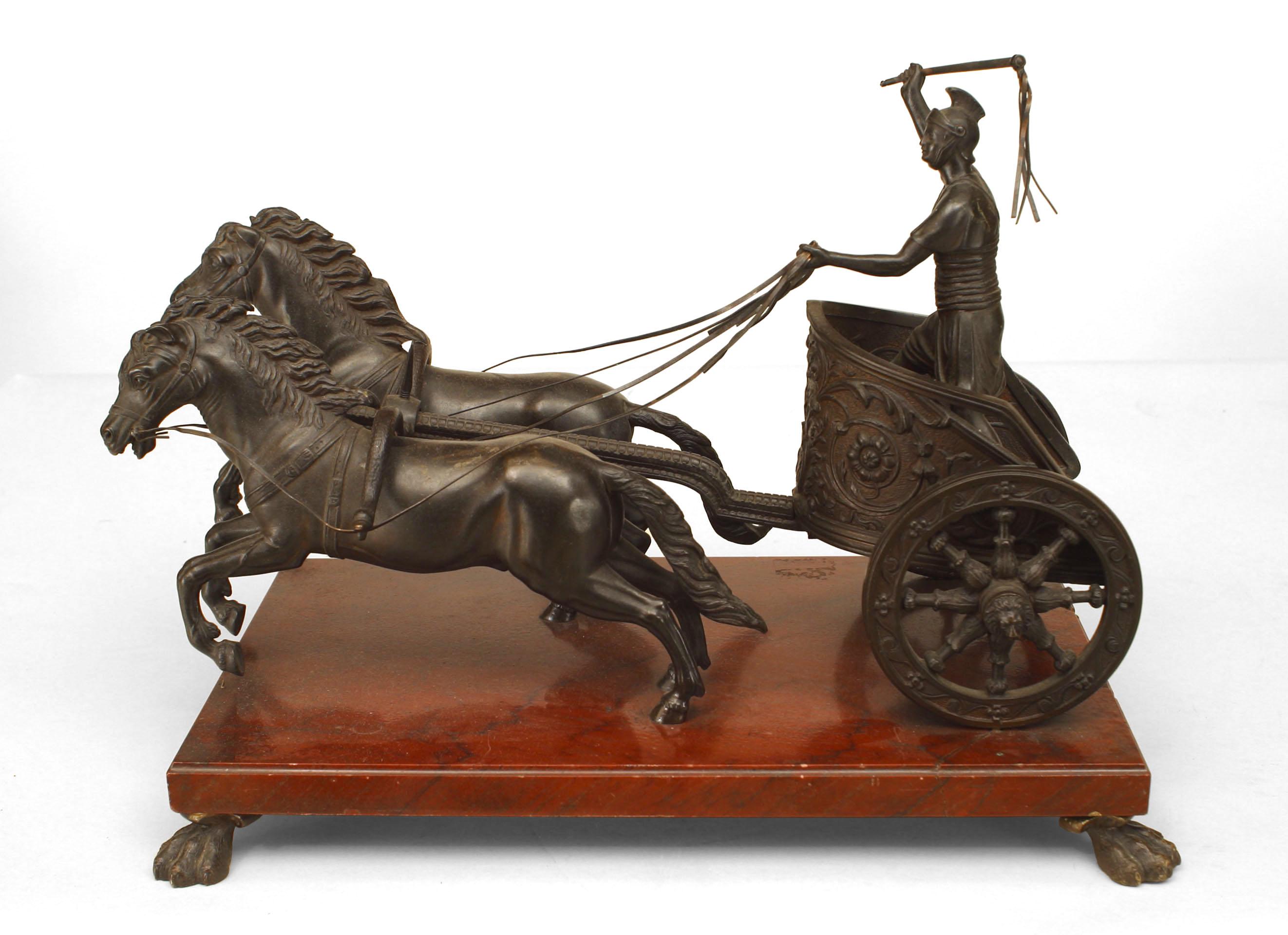 French (19th Cent) bronze figure of a classical Roman soldier riding in a chariot with 2 horses mounted on a rouge marble base resting on claw feet
