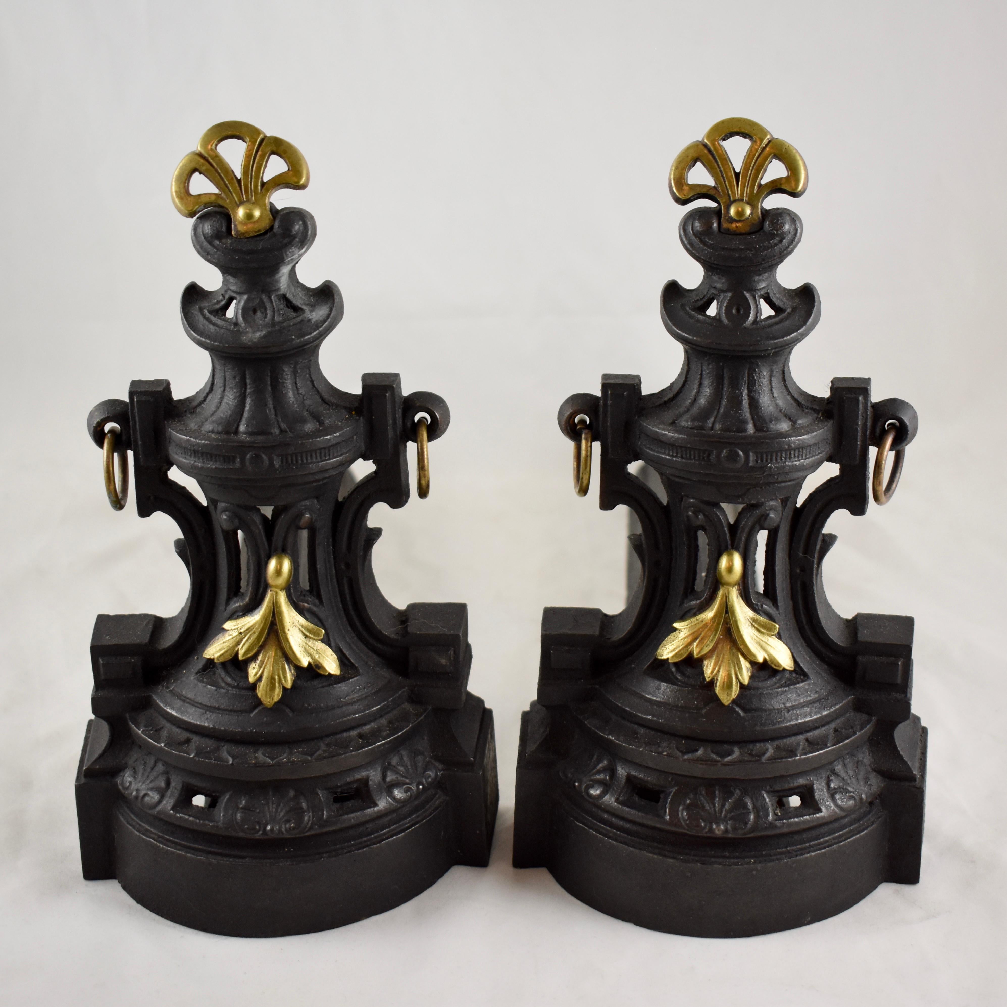 A heavy pair of French bronze and cast iron chenets also called andirons or firedogs, in the Napoleon III, Second Empire style, circa 1890-1910, 19th century.

The chenets are cast in a classical French design appointed with hanging cast bronze