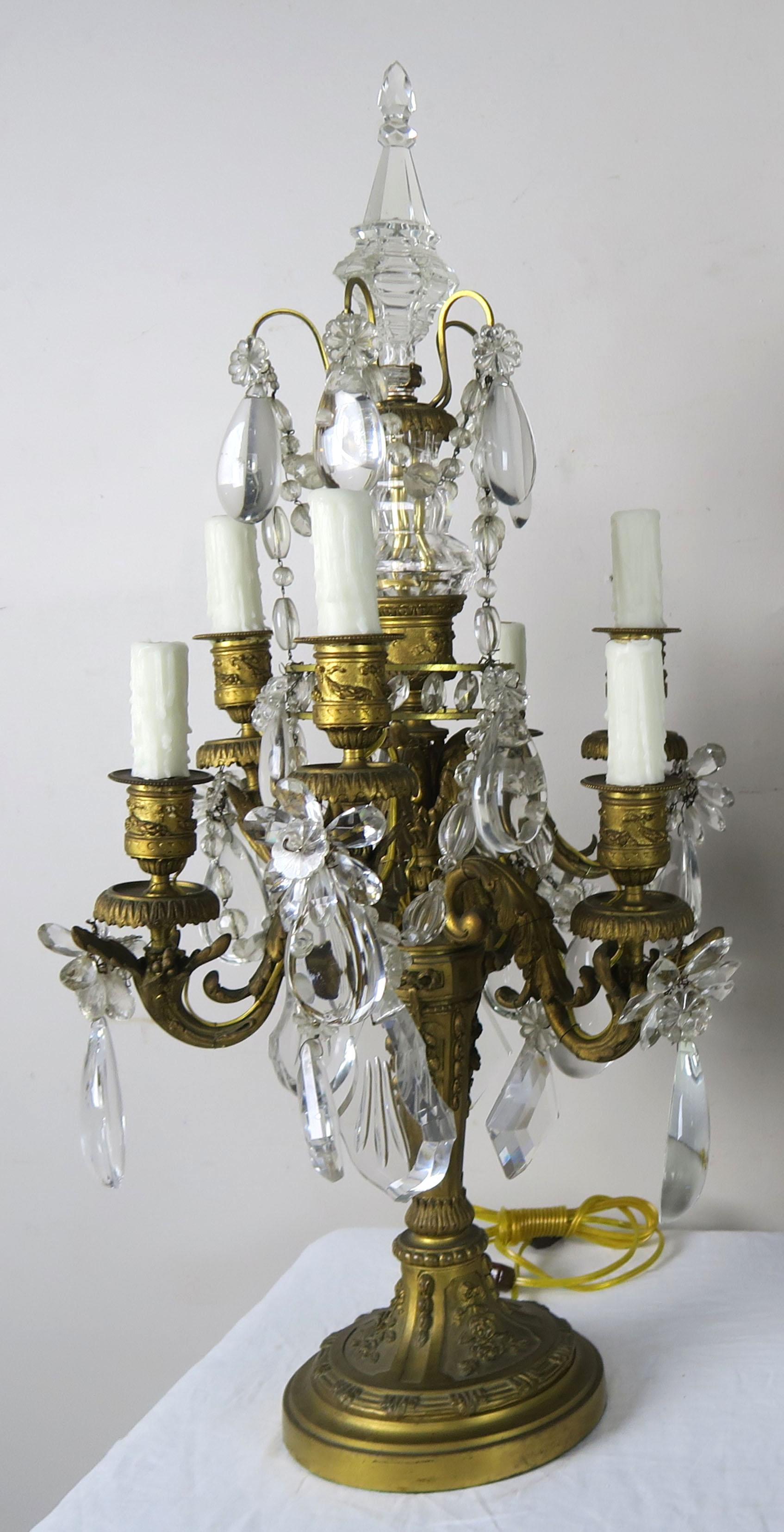 A pair of 19th century French Louis XIV style six light bronze girandles that have been newly electrified with drip wax candle covers. The girandles are adorned with heavy crystal drops, crystal flowers and garlands of crystal beads throughout.