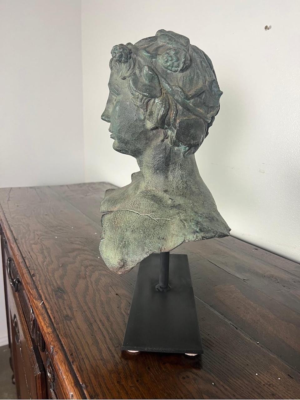 19th century French bronze head of a boy mounted on an iron base.  It is a great accent for a side table or bookshelf.