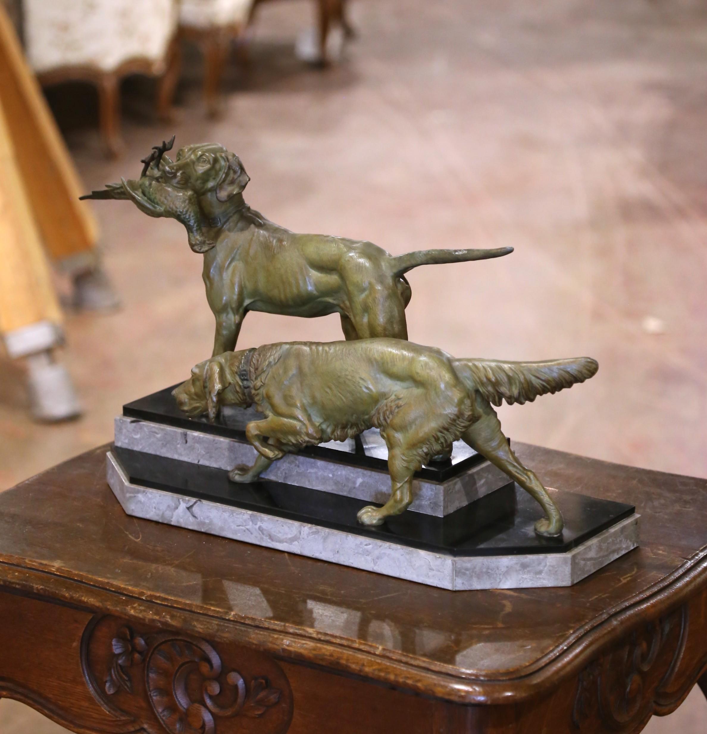 Diese fein modellierte französische Skulptur aus dem späten 19. Jahrhundert ist mit C. Masson signiert und zeigt ein dynamisches Paar Jagdhunde, von denen jeder einen Wildvogel im Maul trägt. Das aus Zinn gegossene und mit einer warmen kupferbraunen