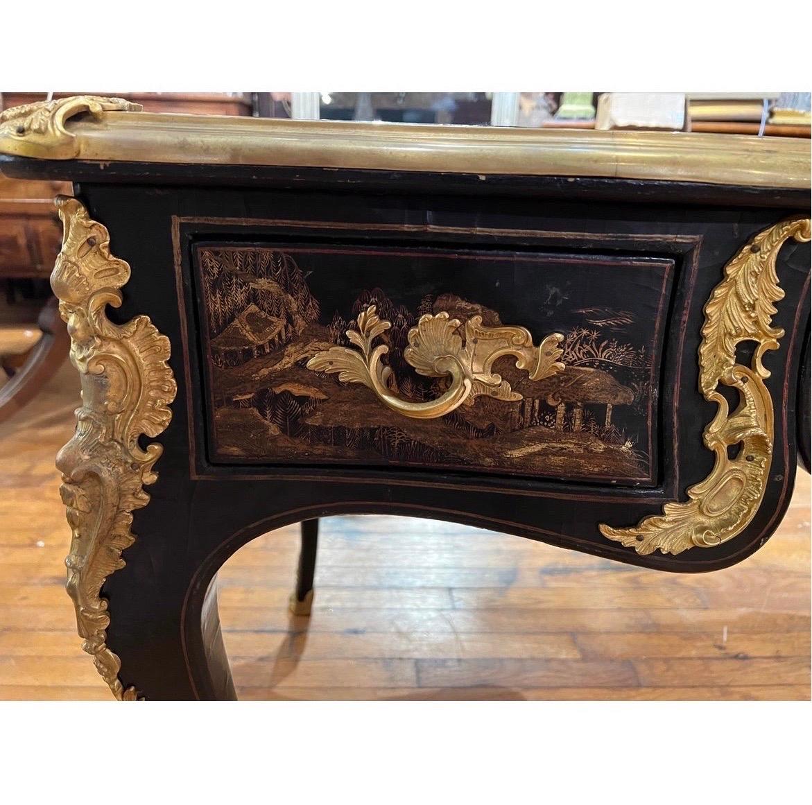 A fantastic antique french chinoiserie desk with impressive bronze ormolu mounting to legs, drawers and edges. Leather top featuring hand tooled gilt design. 3 drawers on one side and faux drawers to verso. Absolutely stunning piece for a collector