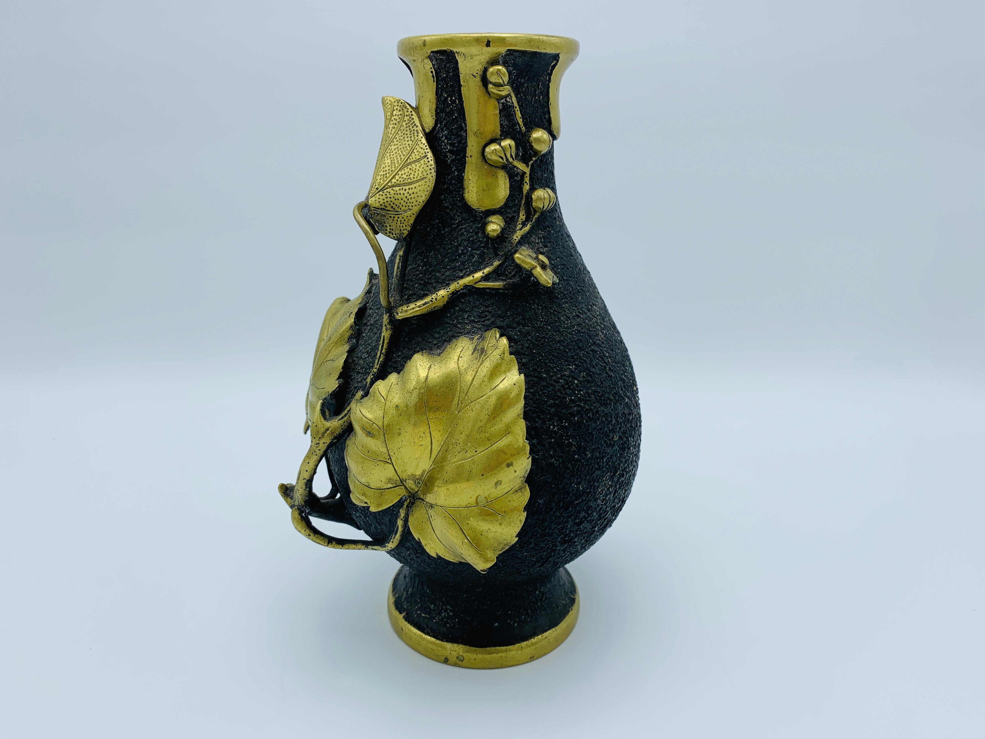 Offered is an exquisite, 19th century French sculptural bronze vase. This piece is handcrafted from bronze, with an intricate, organic trailing of sculptural leaves and berries. The darker, 'black' portion of the vase is a texturized bronze. The