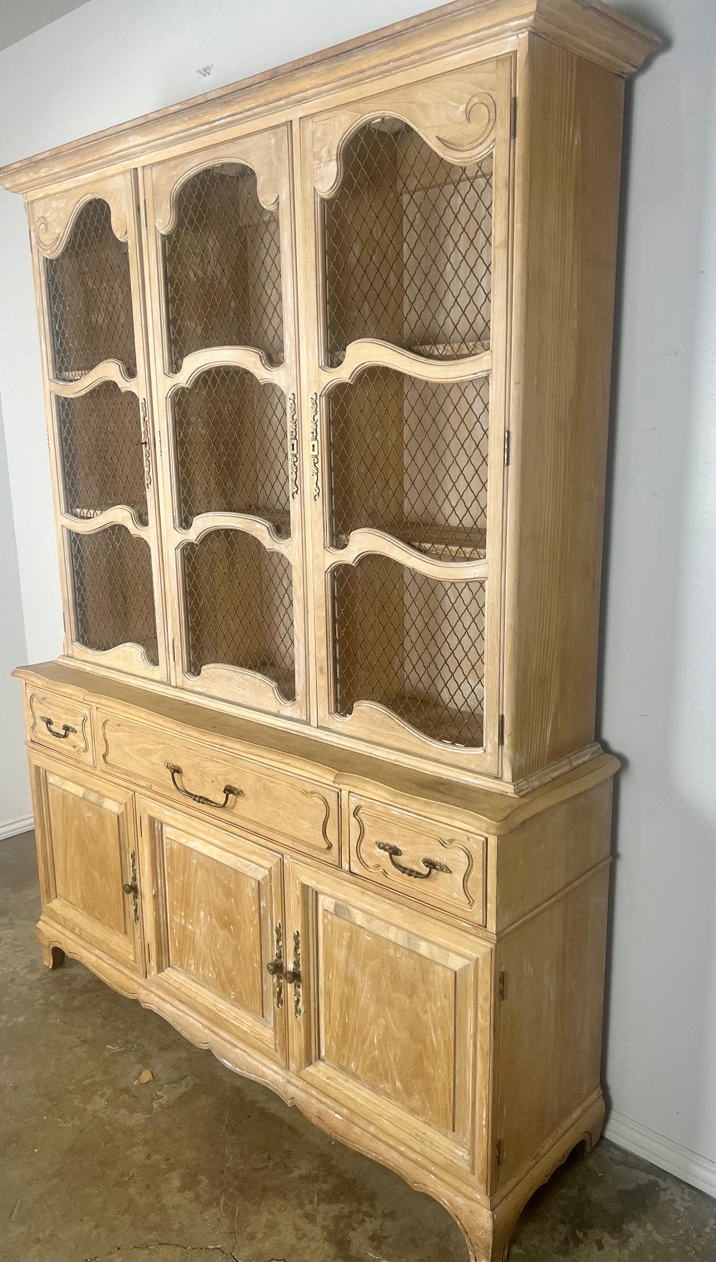 19th century French Louis XV style cabinet with ample storage.  The cabinet has a beautiful weathered finish. Original brass hardware and metal grates inside the doors.
